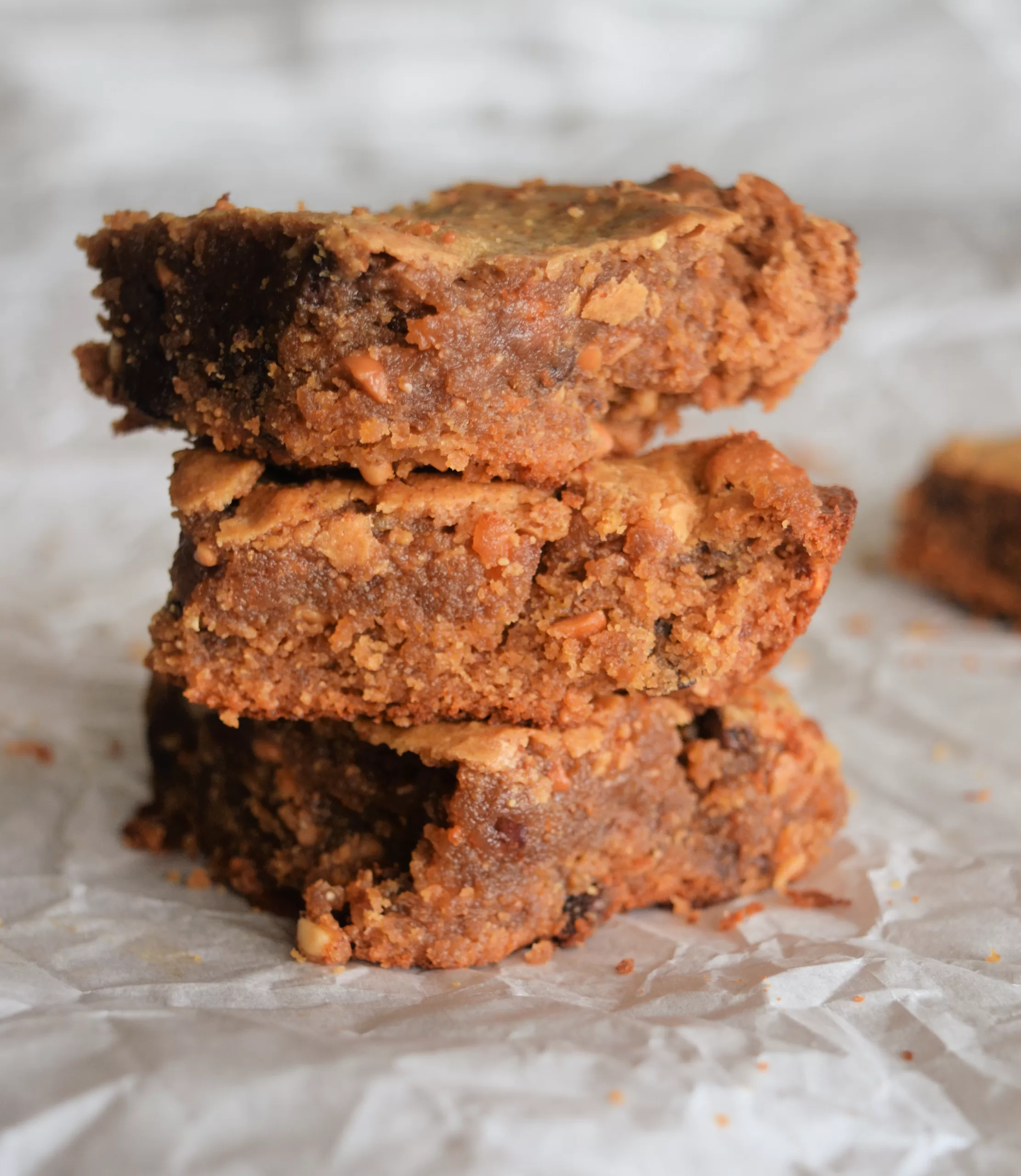 Four flourless gluten free peanut butter cookies stacked on top of each other on a white background.