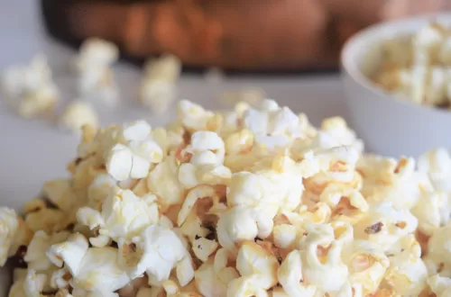 Best Kettle Corn Recipe For a Salty Sweet Snack served in a white bowl on a white countertop.