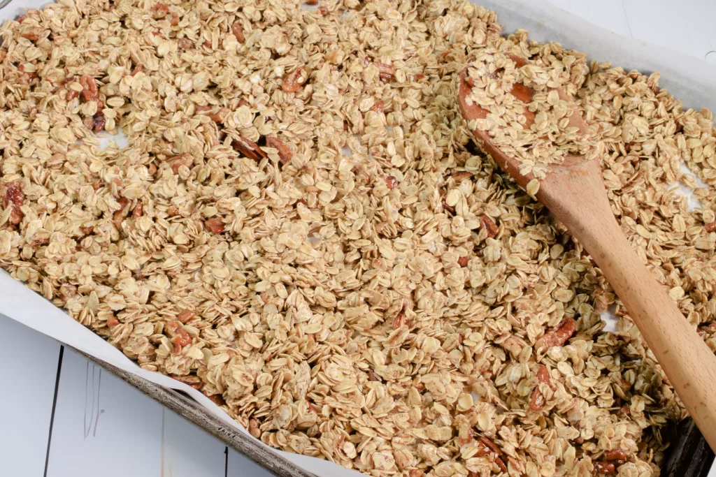 Raw granola spread on a cookie sheet for Best Healthy Homemade Granola (Quick and Easy Recipe).