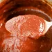 Homemade BBQ sauce on a spoon for The Best Easy Homemade Smoked Meat BBQ Sauce Recipe.