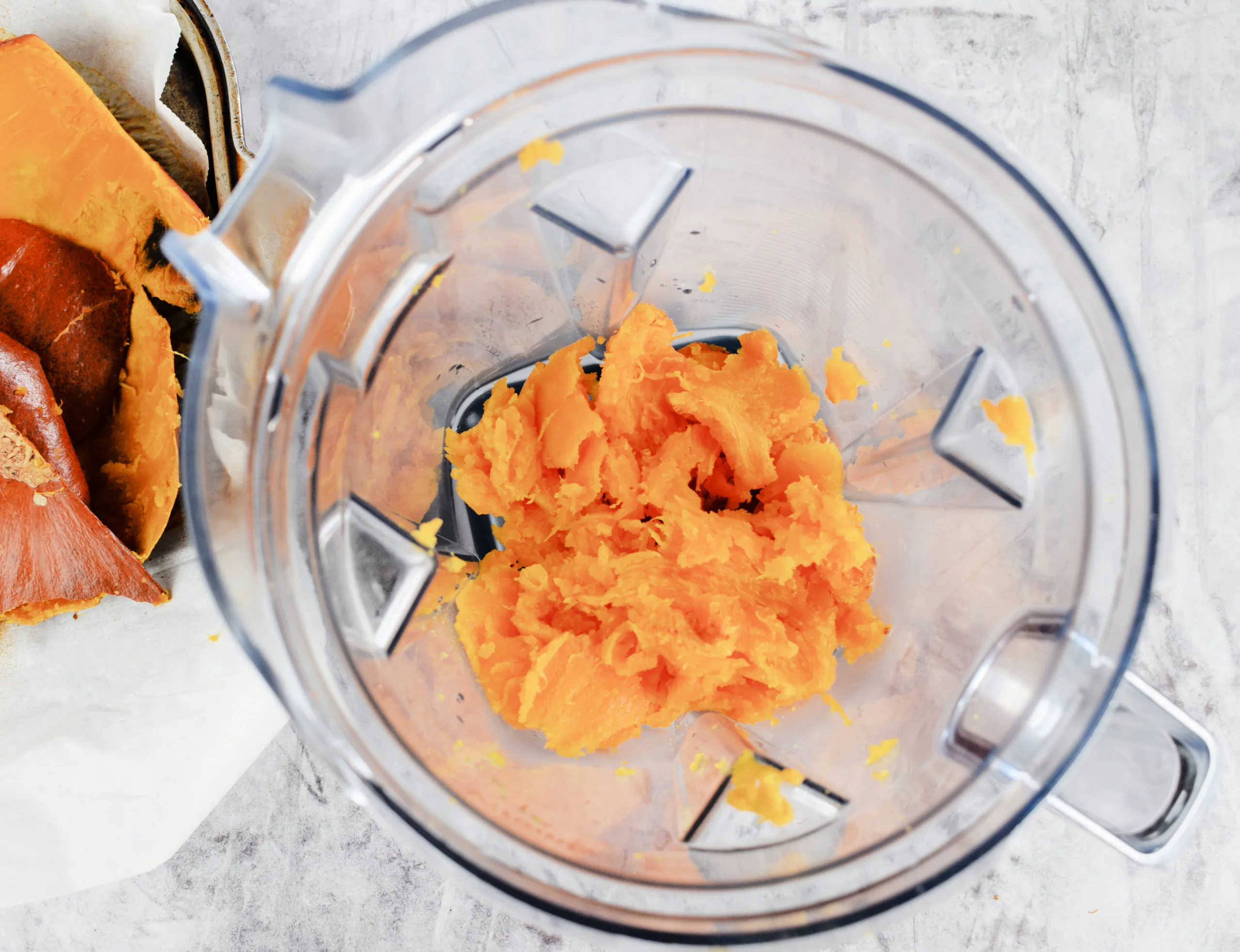 Roasted pumpkin flesh added to a blender to make homemade pumpkin purée.