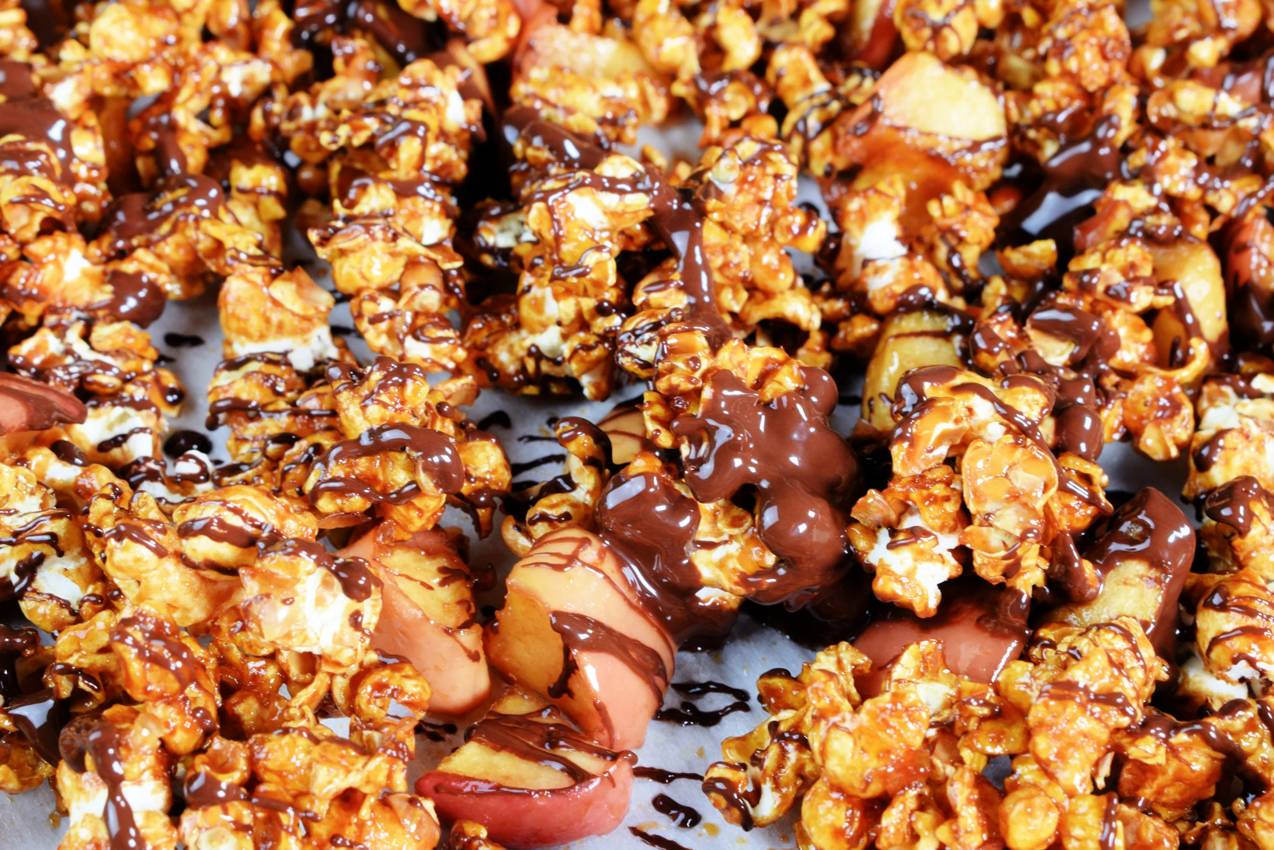 A cookie sheet full of Homemade Caramel Apple Popcorn Without Corn Syrup.