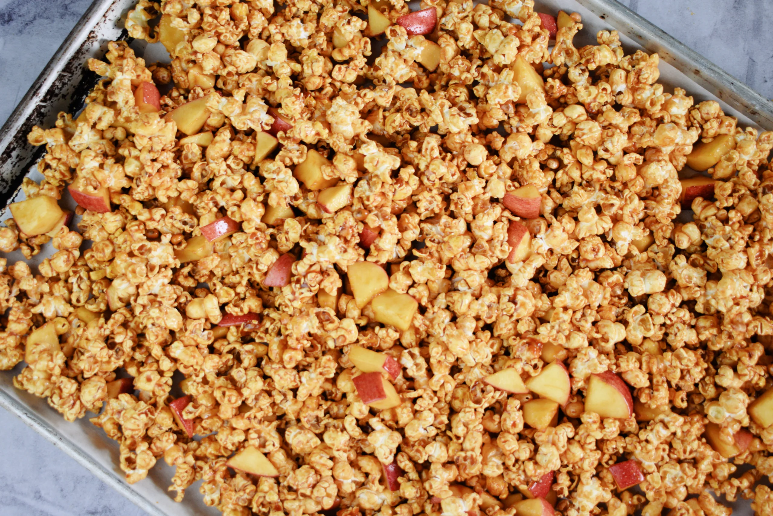 Cookie sheet full of Homemade Caramel Apple Popcorn Without Corn Syrup.