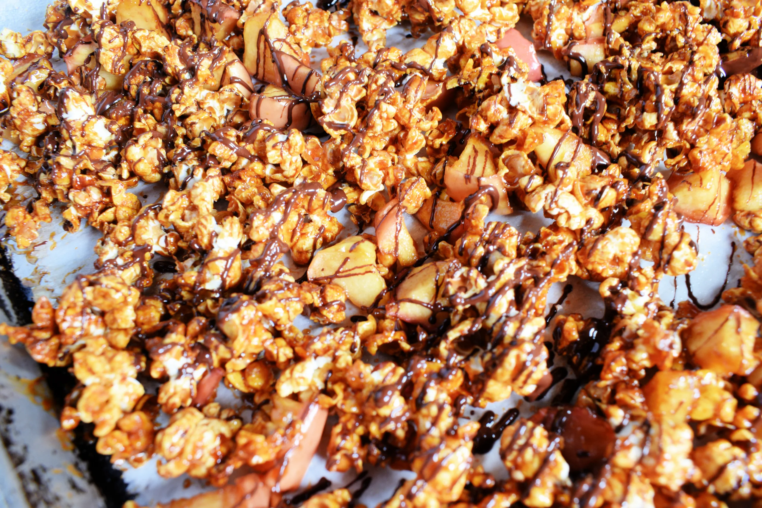 A cookie sheet full of Homemade Caramel Apple Popcorn Without Corn Syrup.