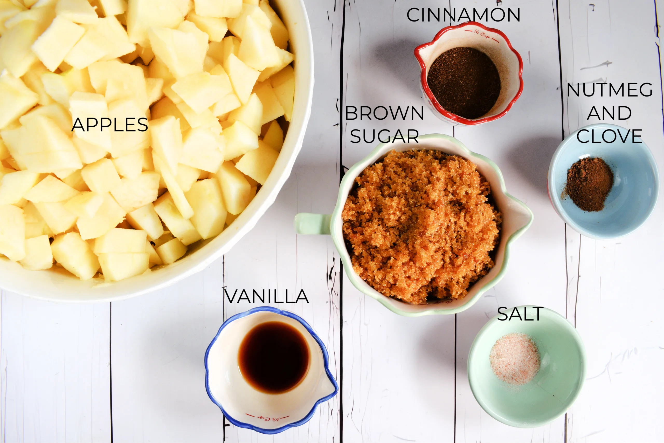 Apple butter ingredients with apples, brown sugar, cinnamon, nutmeg, clove, vanilla, and salt.