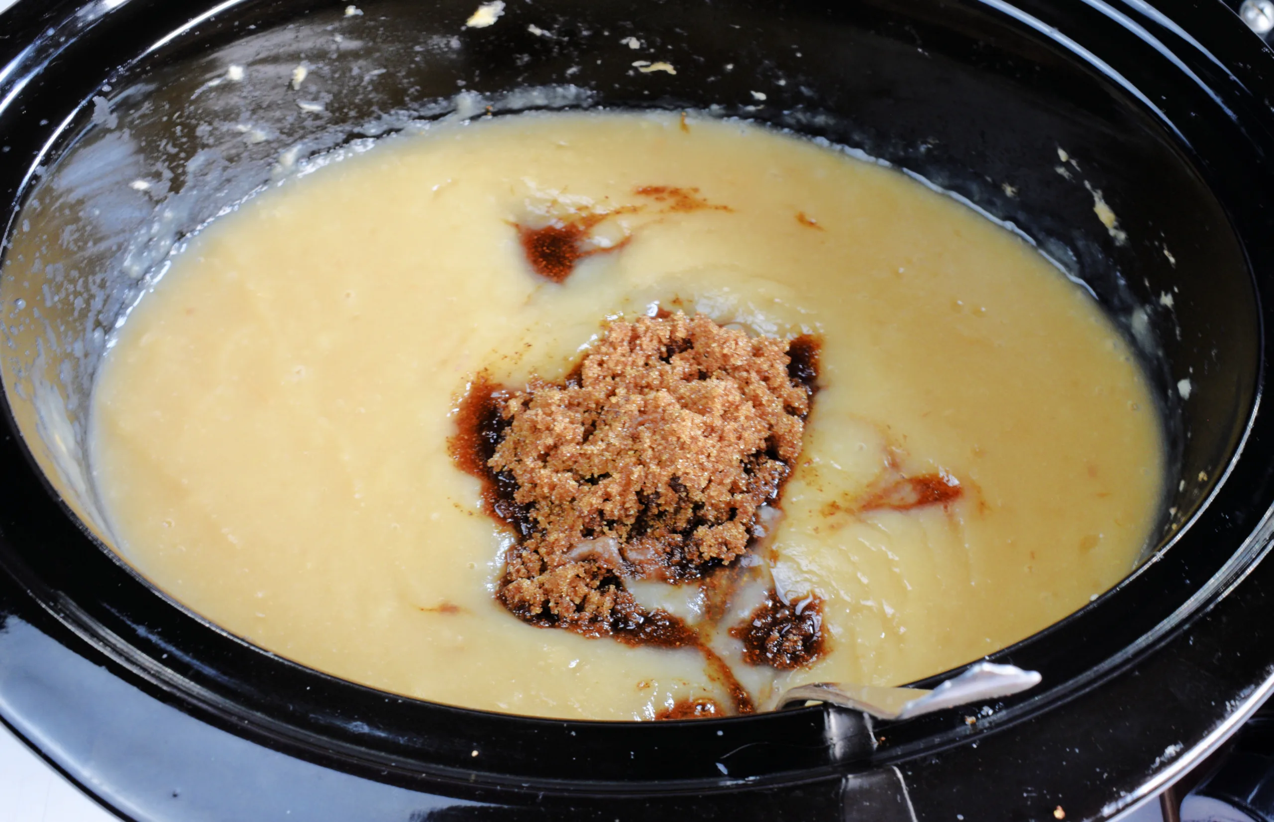 Brown sugar and warm spices added to blended apples for homemade apple butter.
