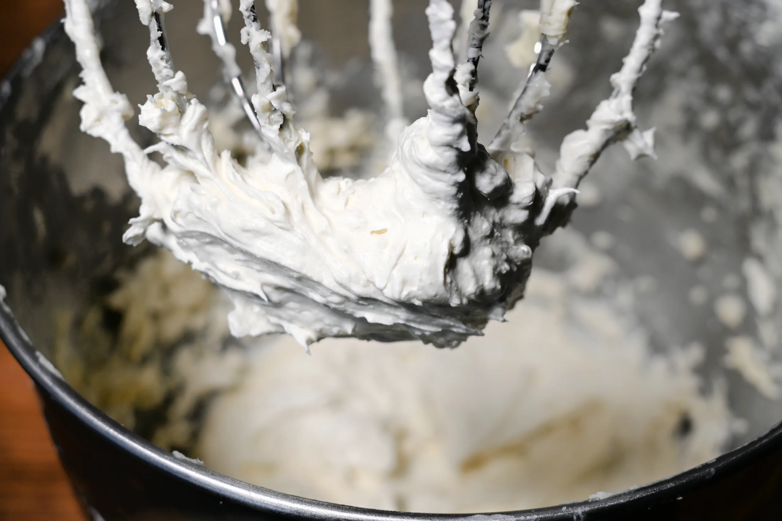 Whipped tallow balm on a mixer whisk attachment after being whipped until light and creamy
