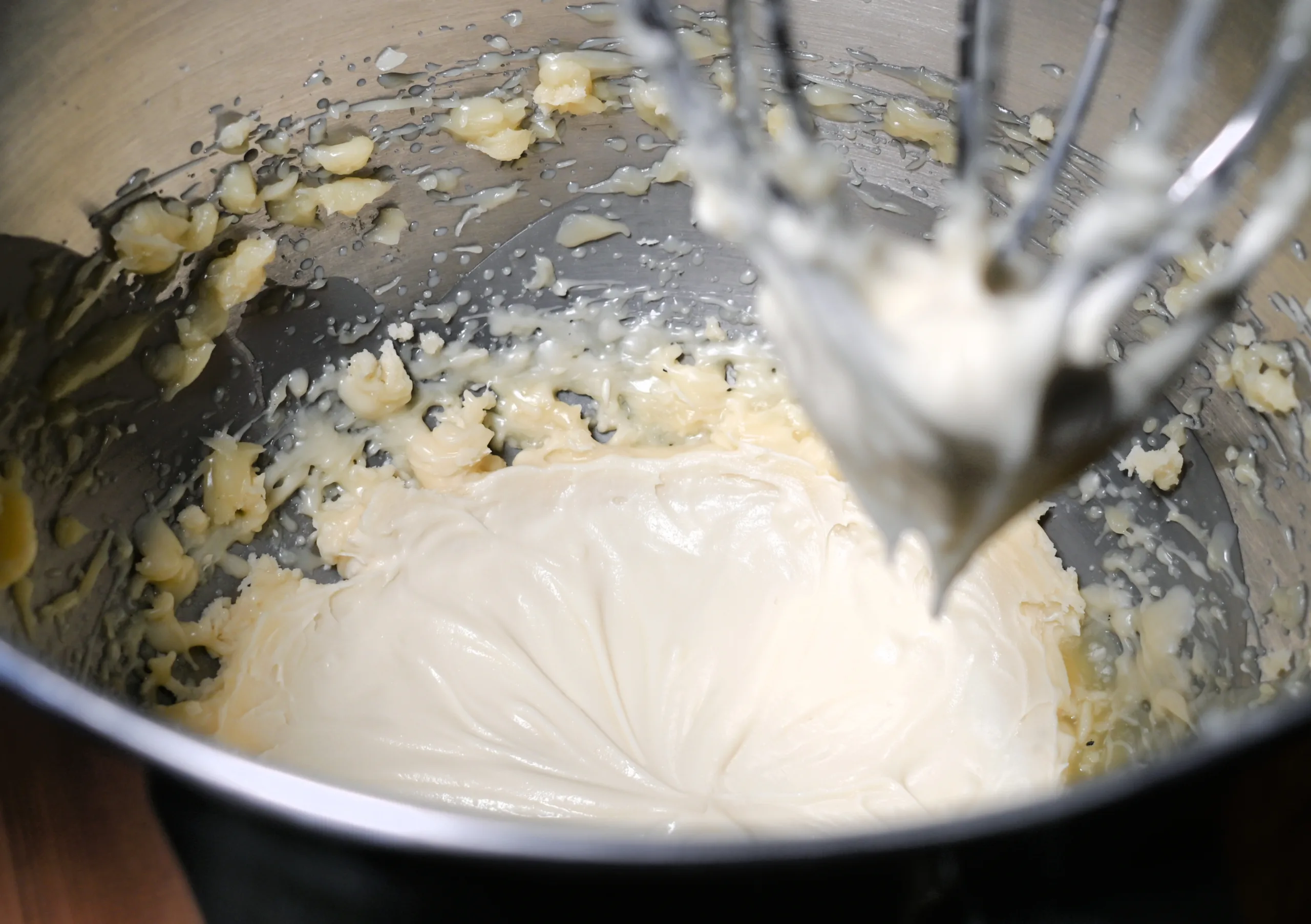 Homemade tallow balm being whipped in a mixing bowl until smooth and creamy