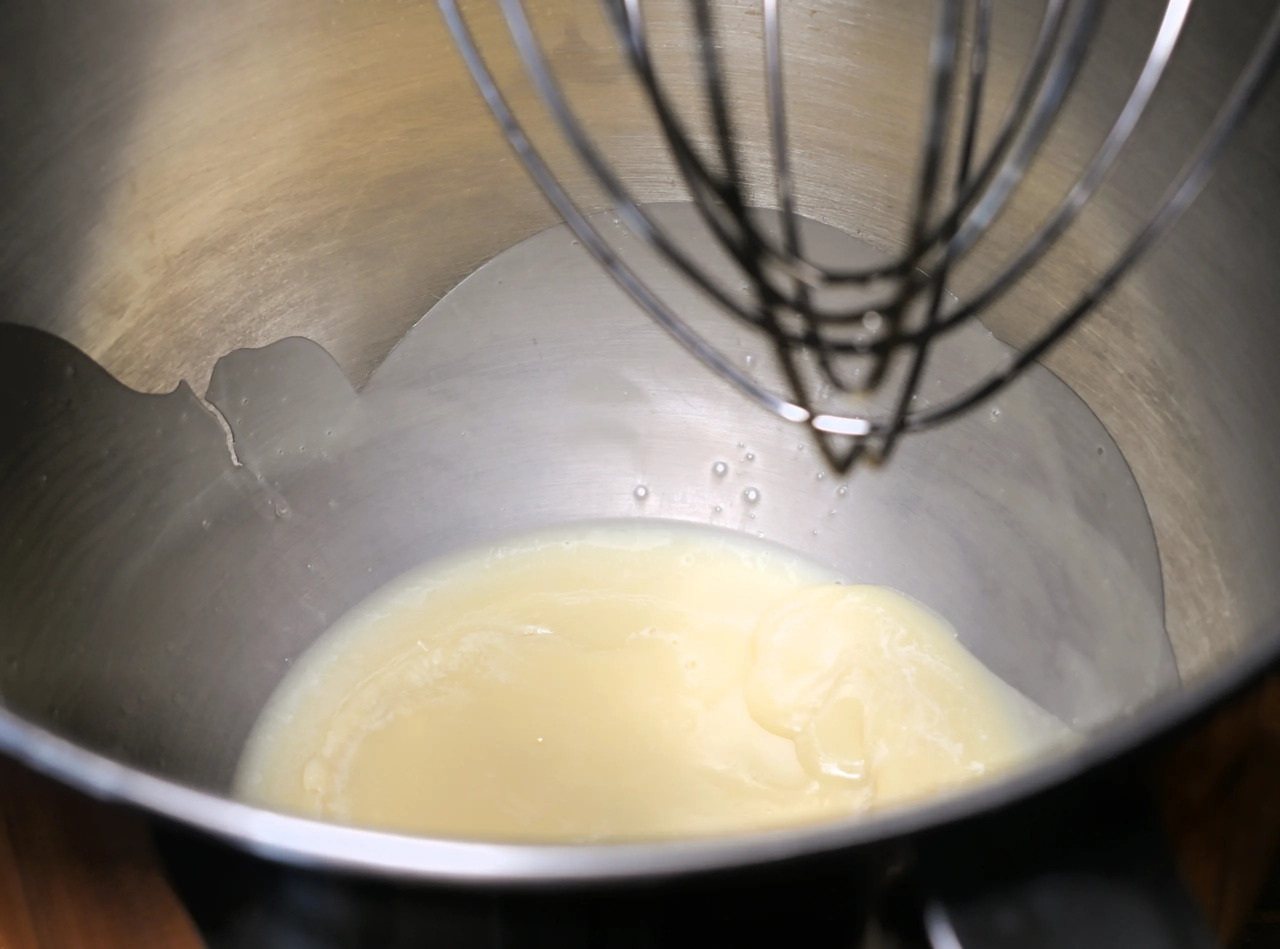 Melted tallow and oil in a stand mixer bowl before whipping into tallow balm