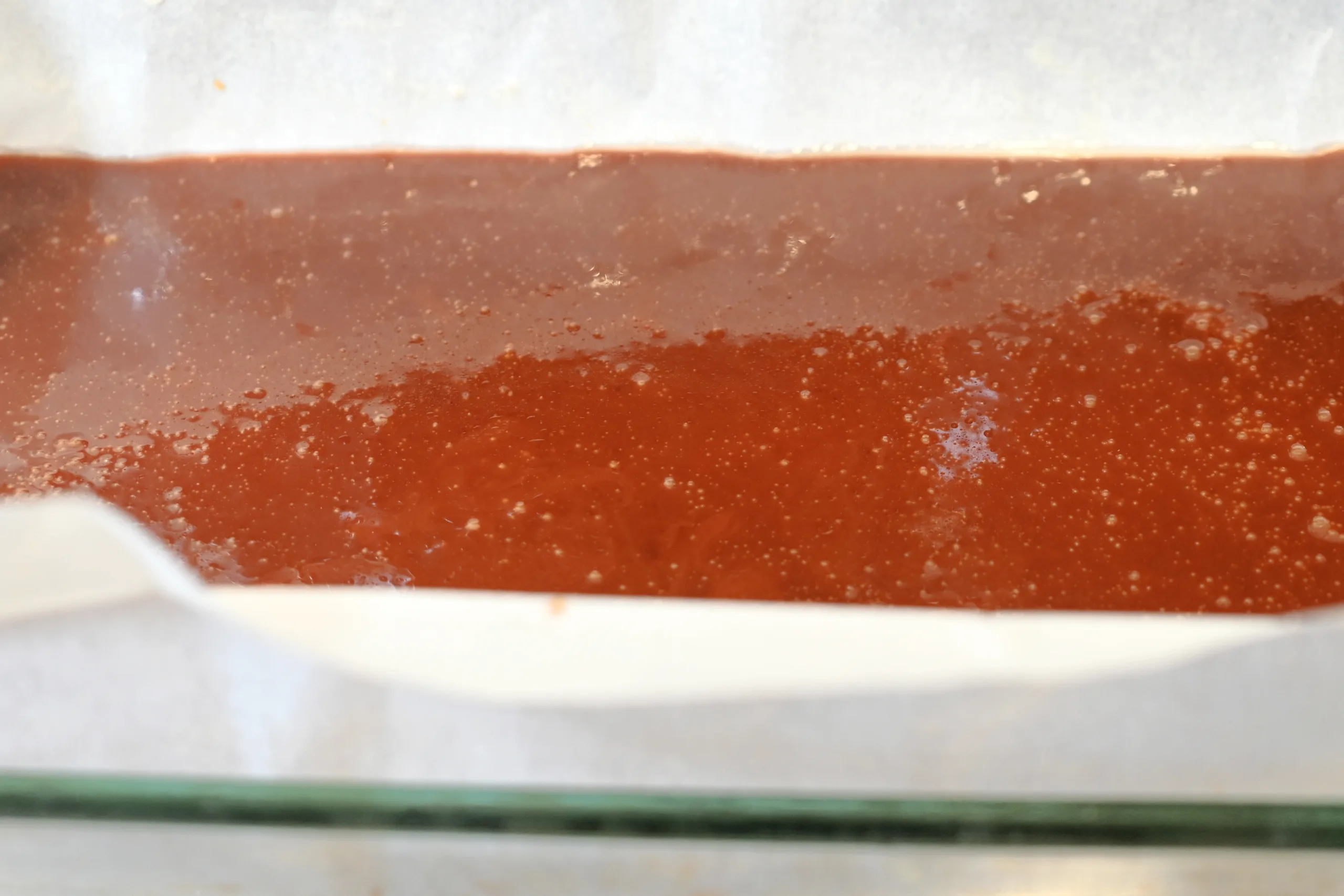 Set caramel in a parchment-lined pan before cutting into chewy candy pieces.