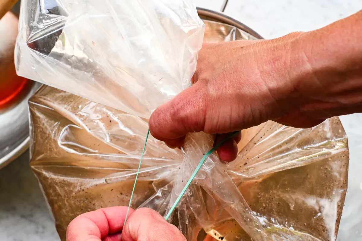 Securing a brining bag filled with seasoned liquid in preparation for wet brining a whole turkey