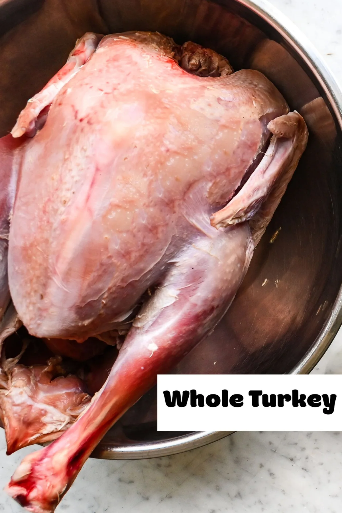 Raw whole turkey in a large metal bowl, labeled for brining and preparation before smoking.