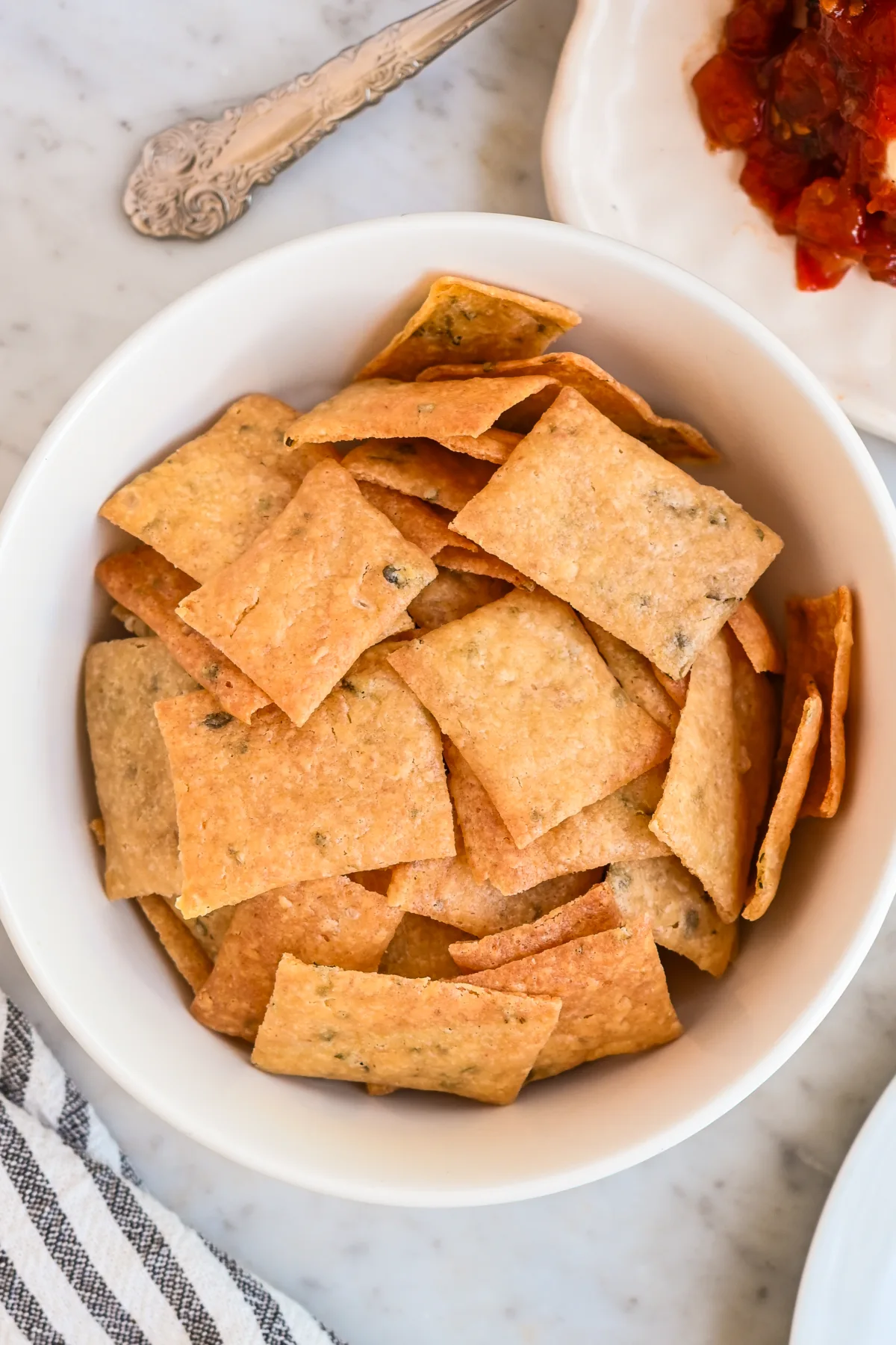 Golden brown homemade sourdough discard crackers in a bowl—perfect for charcuterie boards or as a substitute for store-bought crackers.