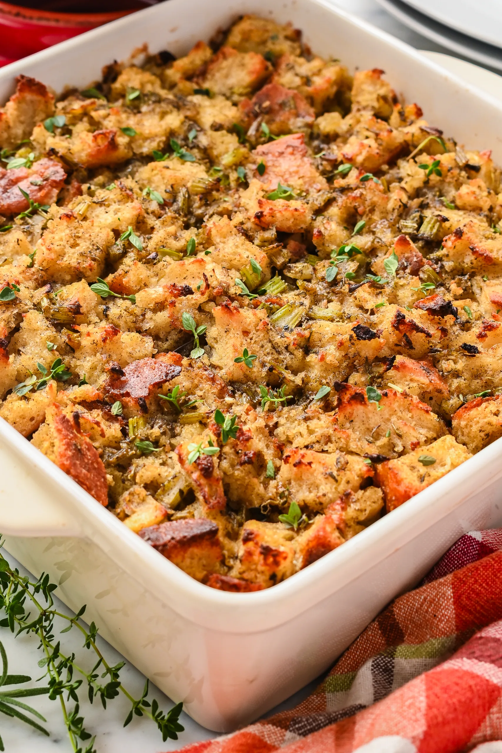 Sourdough stuffing mixture in baking dish topped with pieces of butter before baking for a golden brown crispy top.