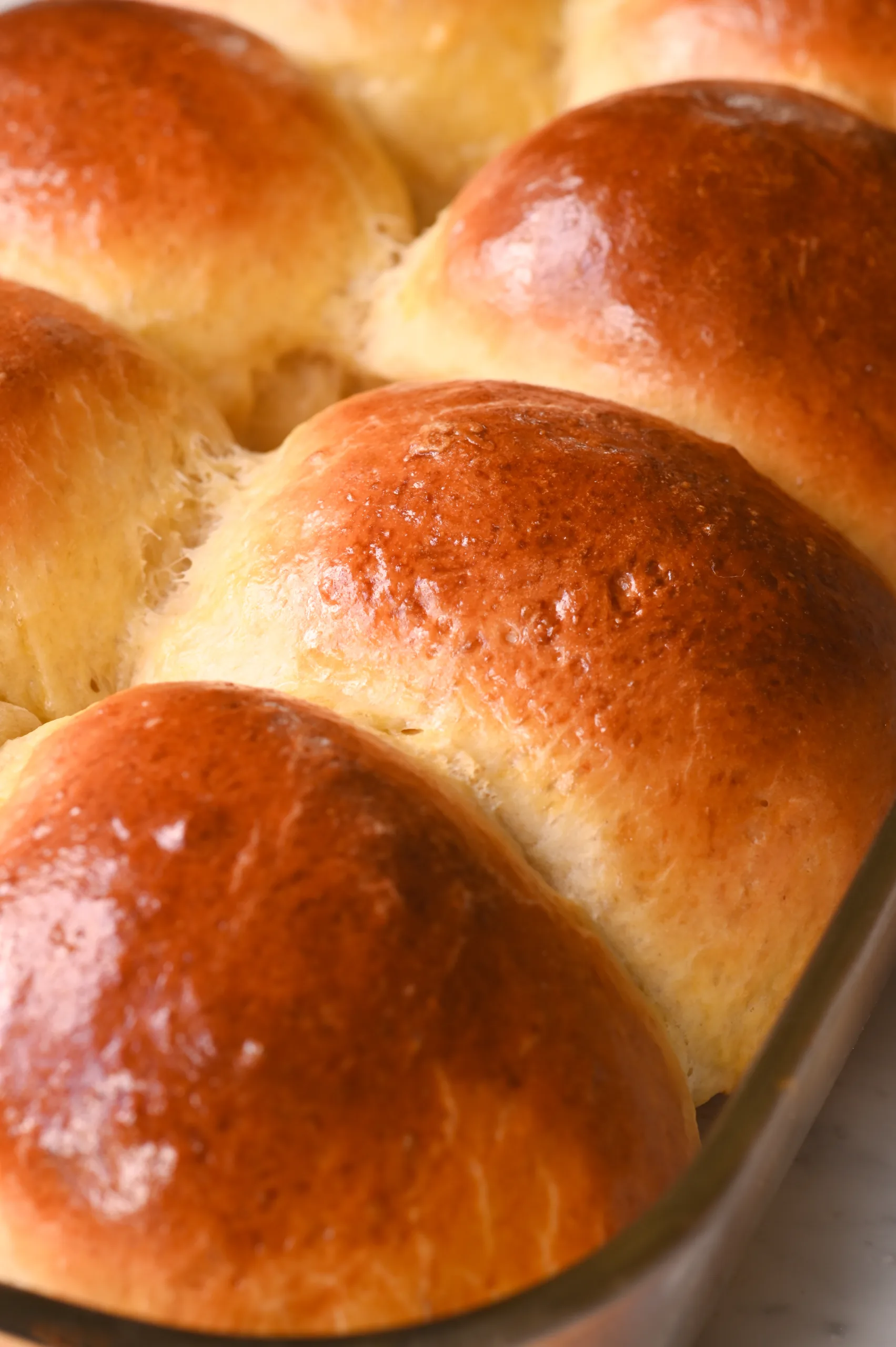 Close-up of freshly baked soft sourdough discard rolls with a golden brown crust and fluffy interior.
