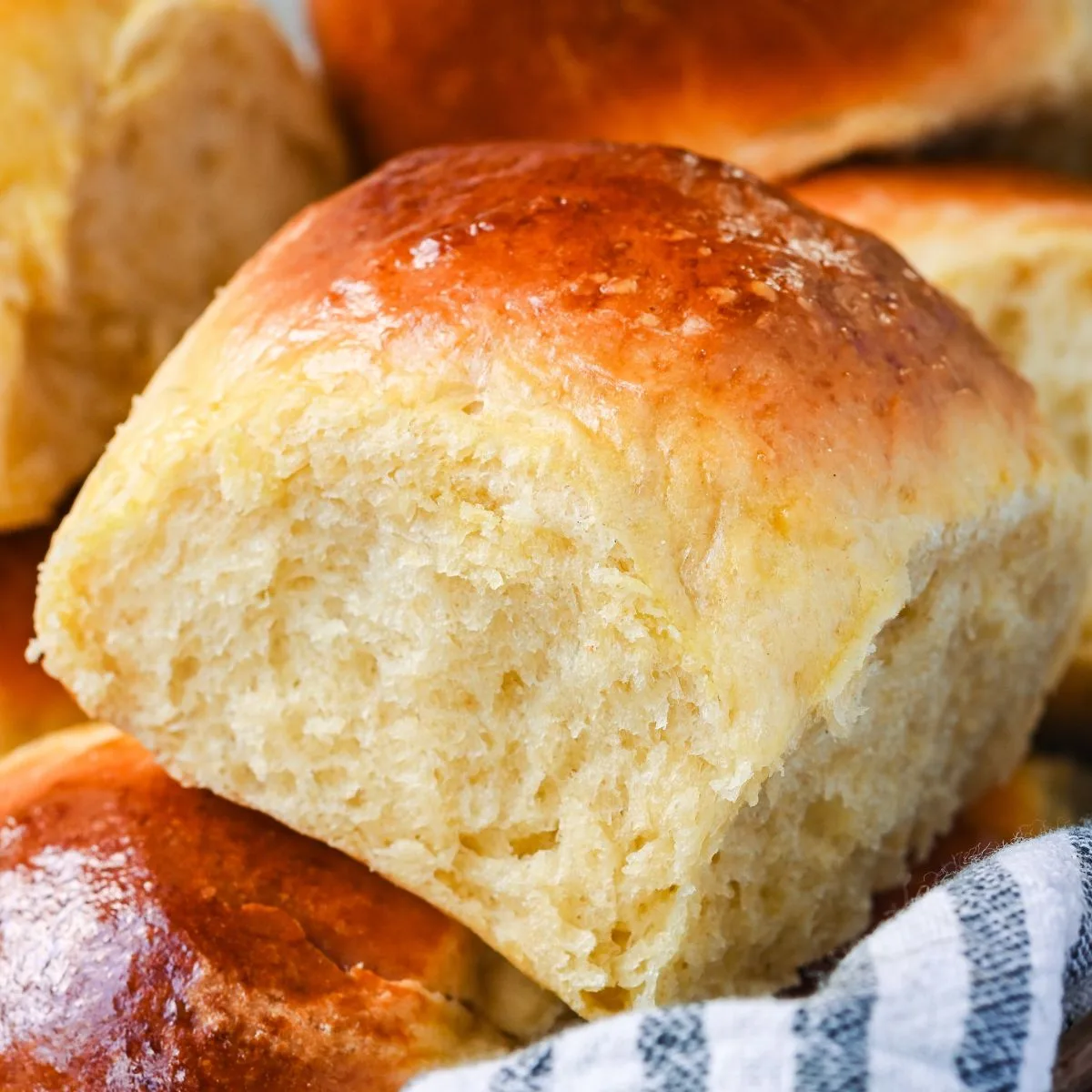 Close-up of freshly baked soft sourdough discard rolls with a golden brown crust and fluffy interior.