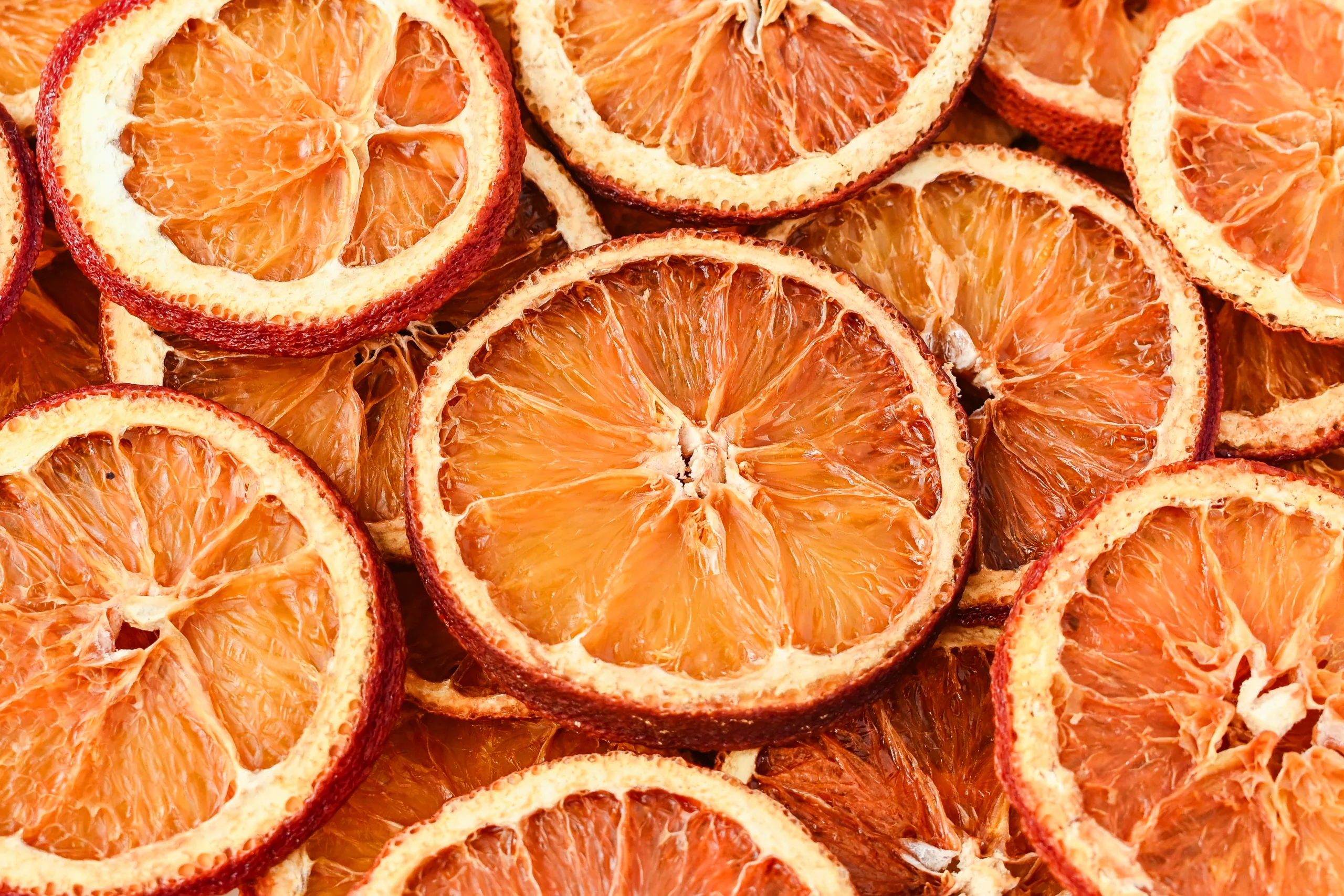 Overhead view of dehydrated orange slices with rich amber tones, perfect for holiday decor and simmer pots.