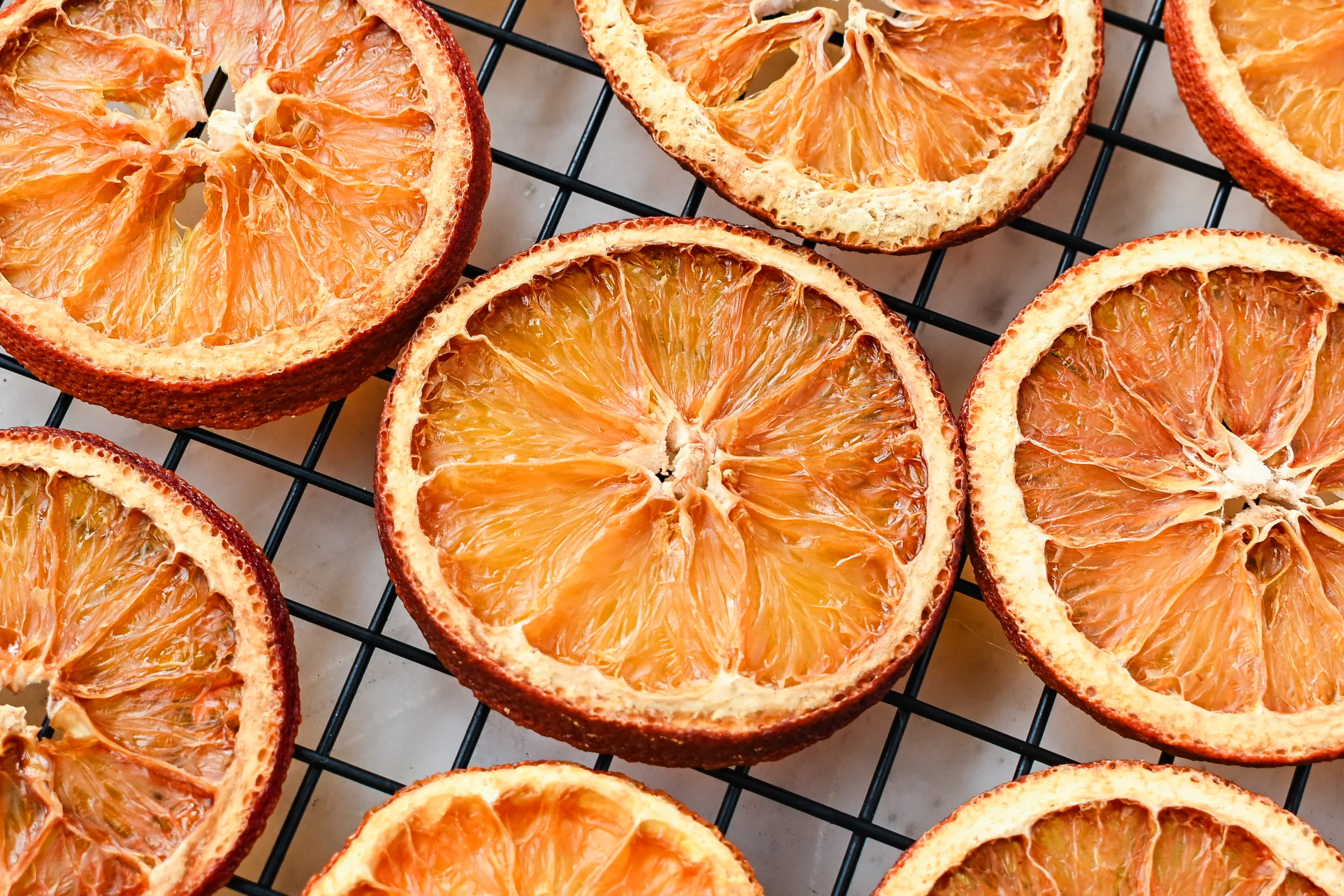 Overhead view of dehydrated orange slices with rich amber tones, perfect for holiday decor and simmer pots.
