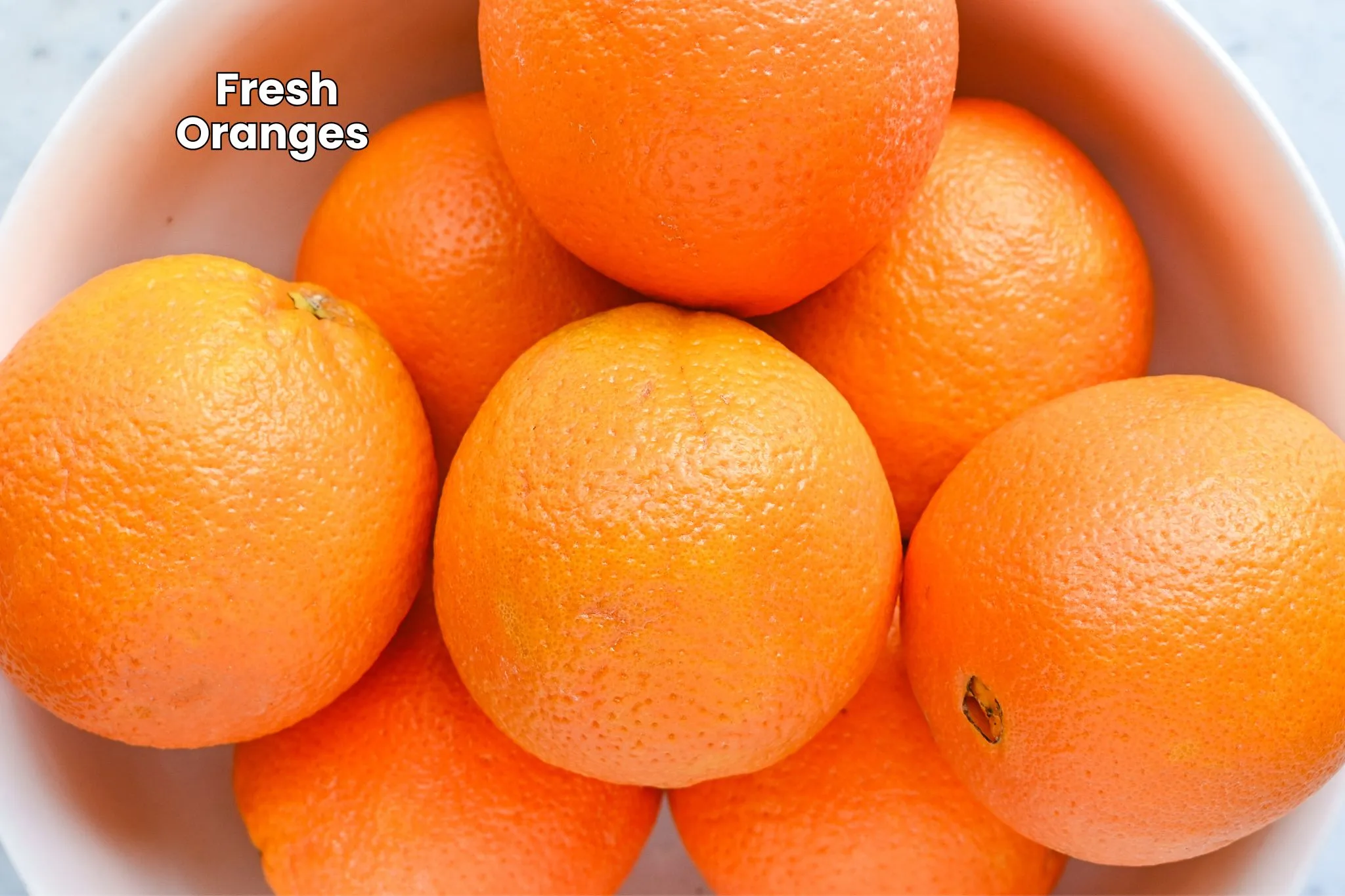 Fresh whole oranges with bright orange peels, ready to be sliced for homemade dried orange slices.
