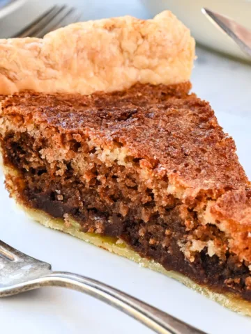 Slice of Pennsylvania Dutch Funny Cake showing layers of chocolate and vanilla inside a flaky pie crust.