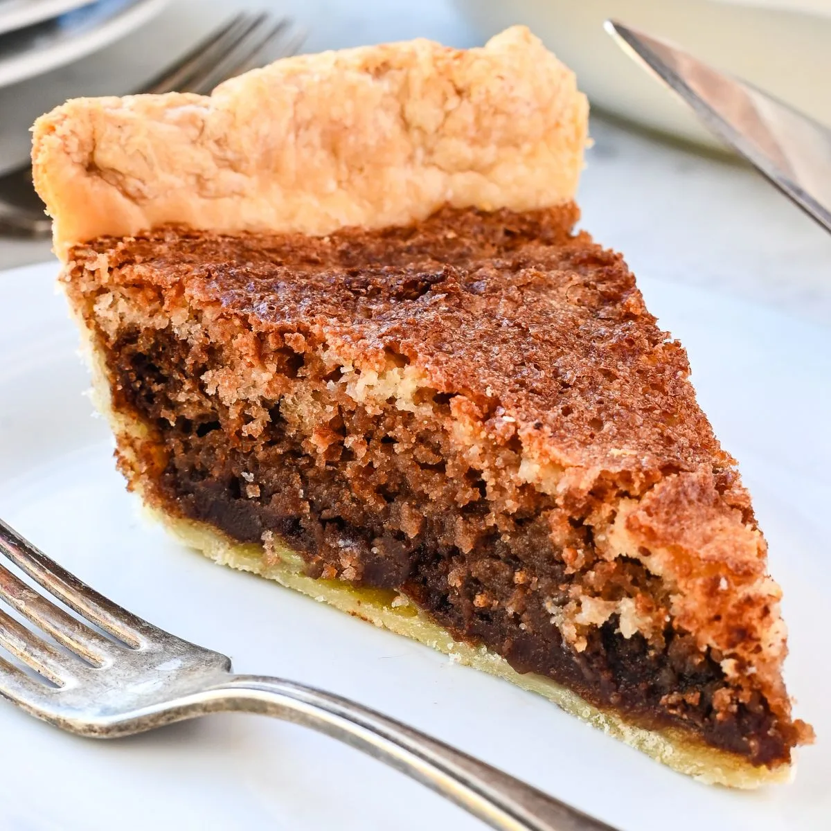 Slice of Pennsylvania Dutch Funny Cake showing layers of chocolate and vanilla inside a flaky pie crust.