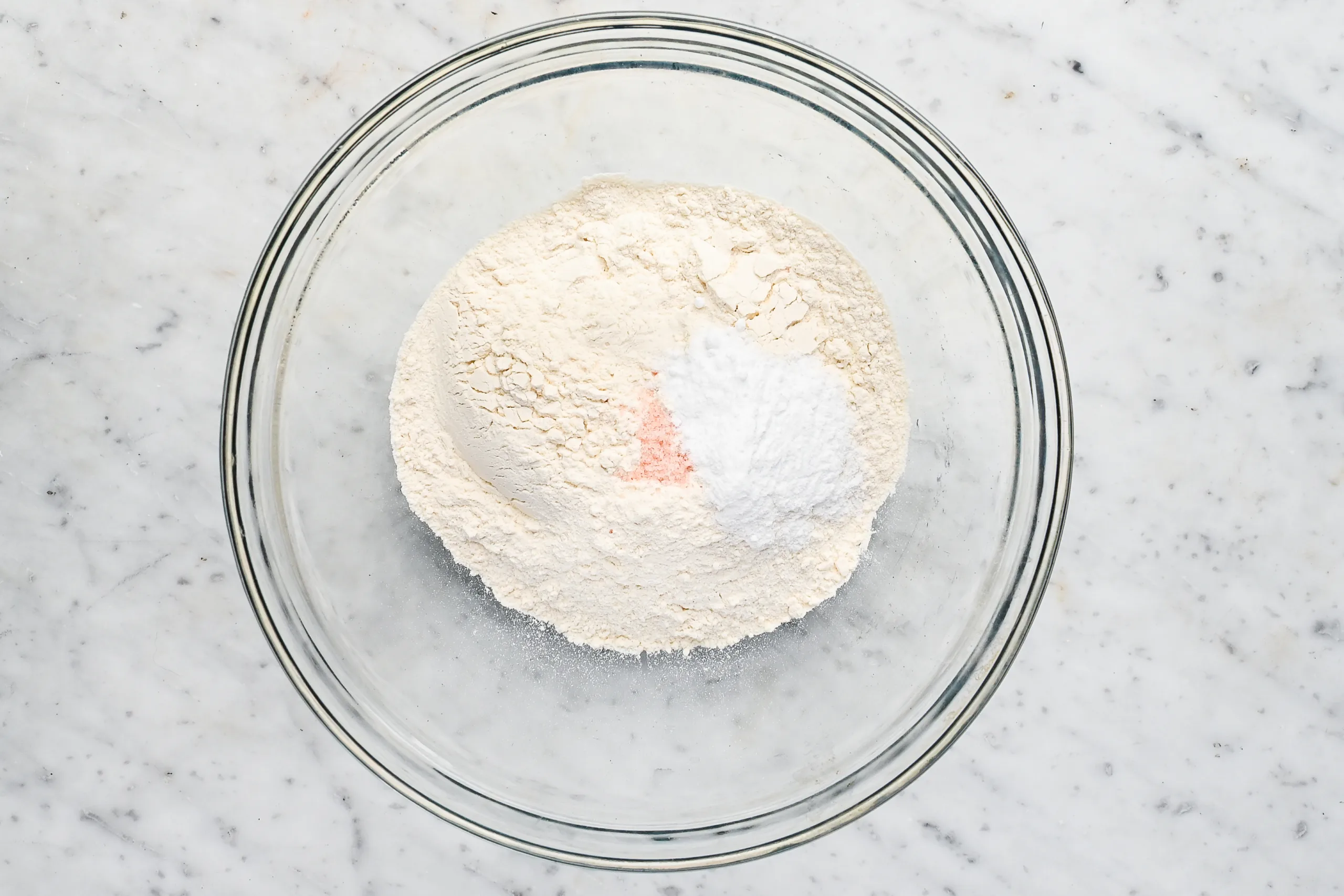 Mixing flour, baking powder, and salt together in a clear glass bowl for the Funny Cake base.