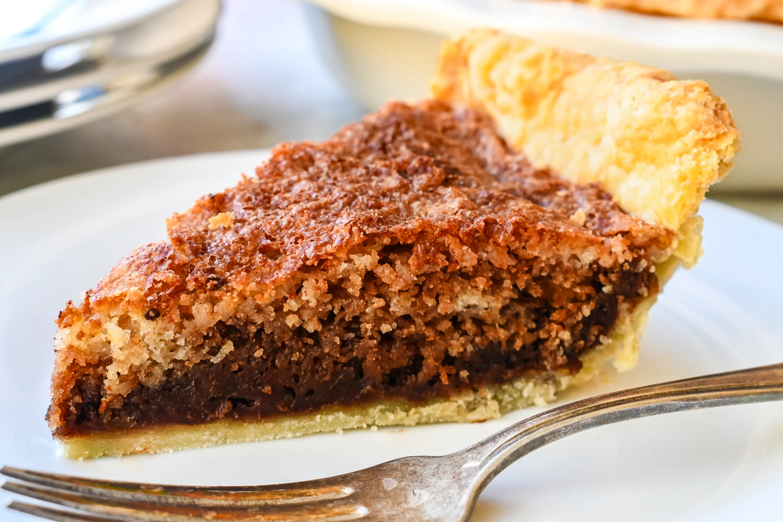 Slice of Pennsylvania Dutch Funny Cake showing layers of chocolate and vanilla inside a flaky pie crust.