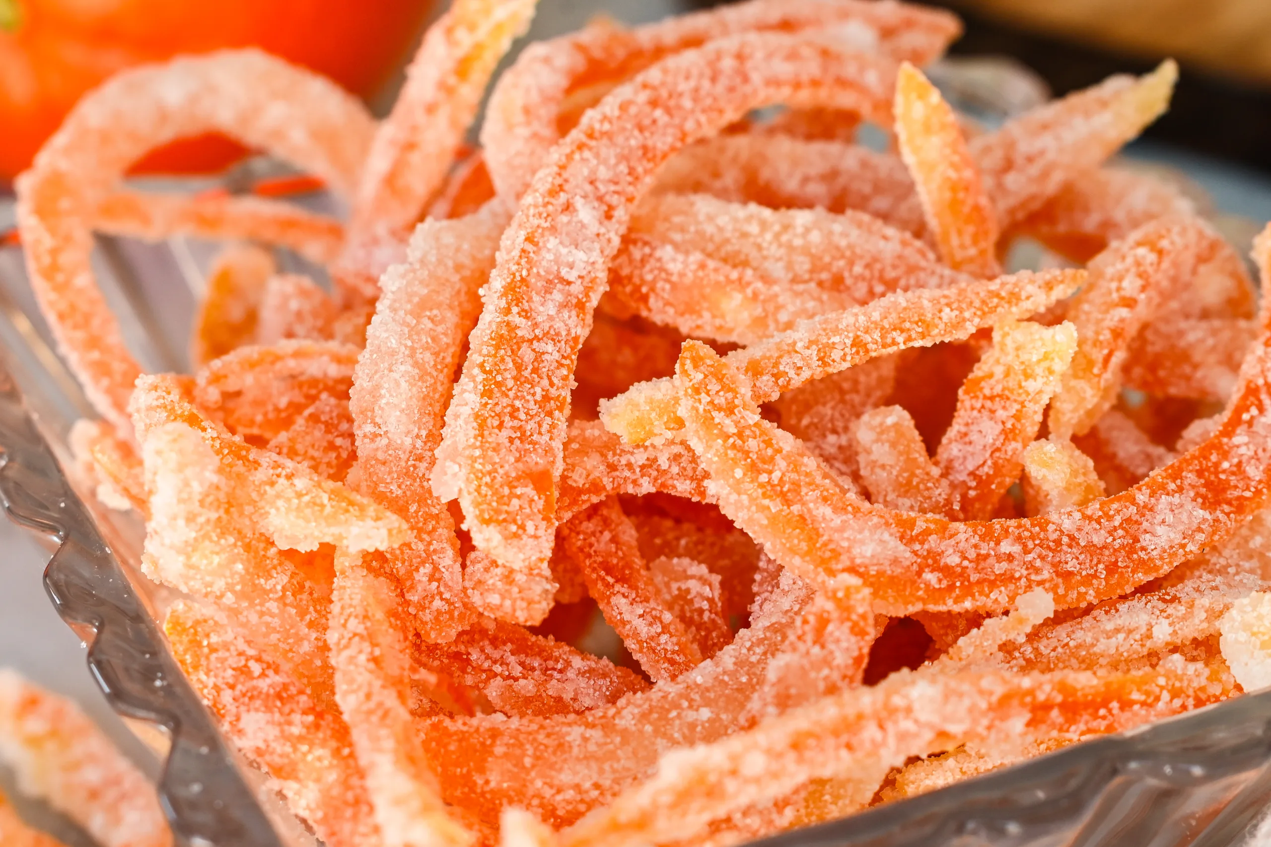 Close-up of sugar-coated candied orange peels showing their soft texture and crystallized coating.