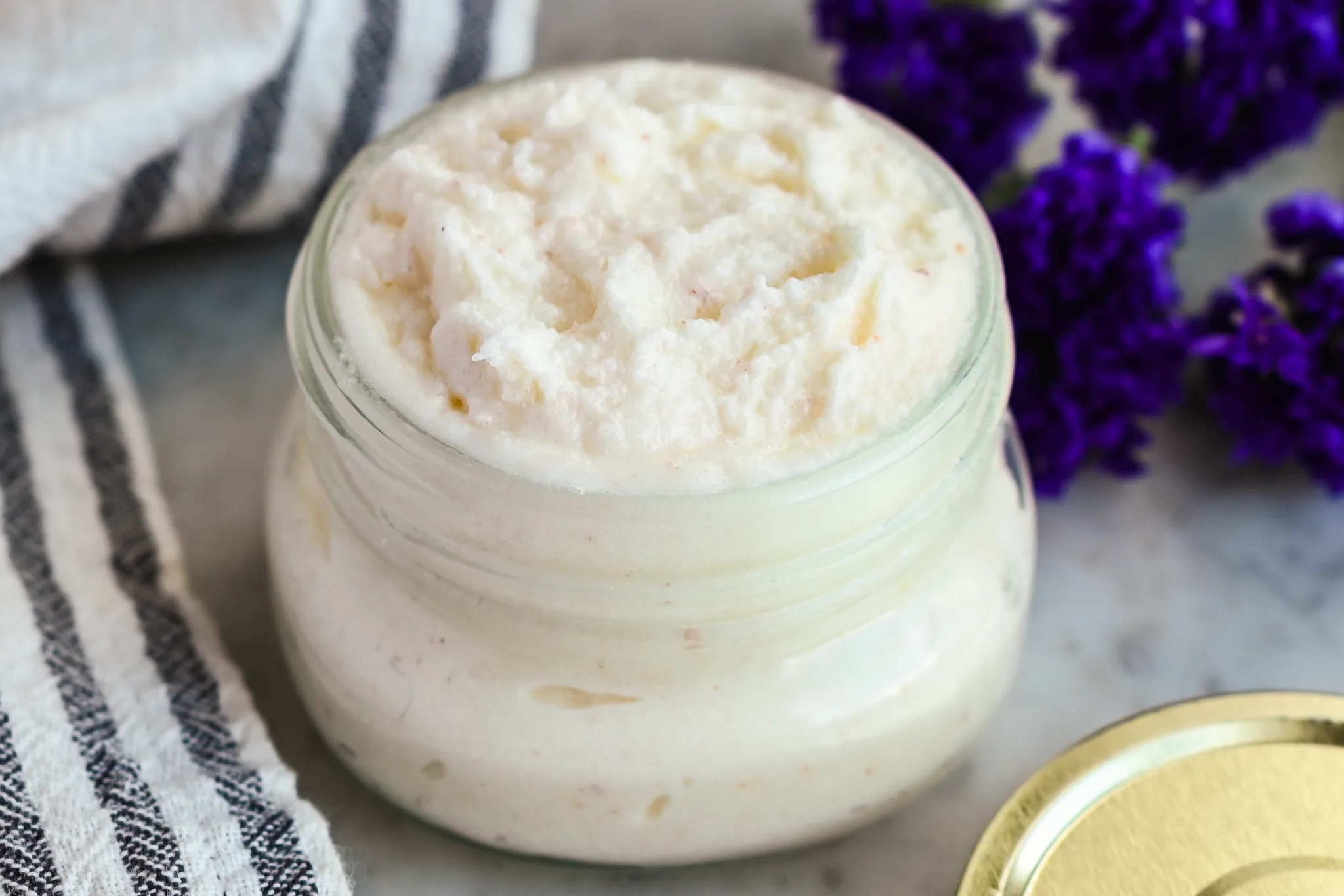 Homemade beef tallow candle in a mason jar labeled with lavender essential oil – clean-burning natural candle with a rustic and eco-friendly look.