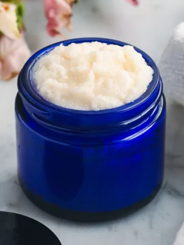 Finished homemade tallow face scrub with a soft, whipped sugar texture stored in a blue glass jar, ready for gentle facial exfoliation.