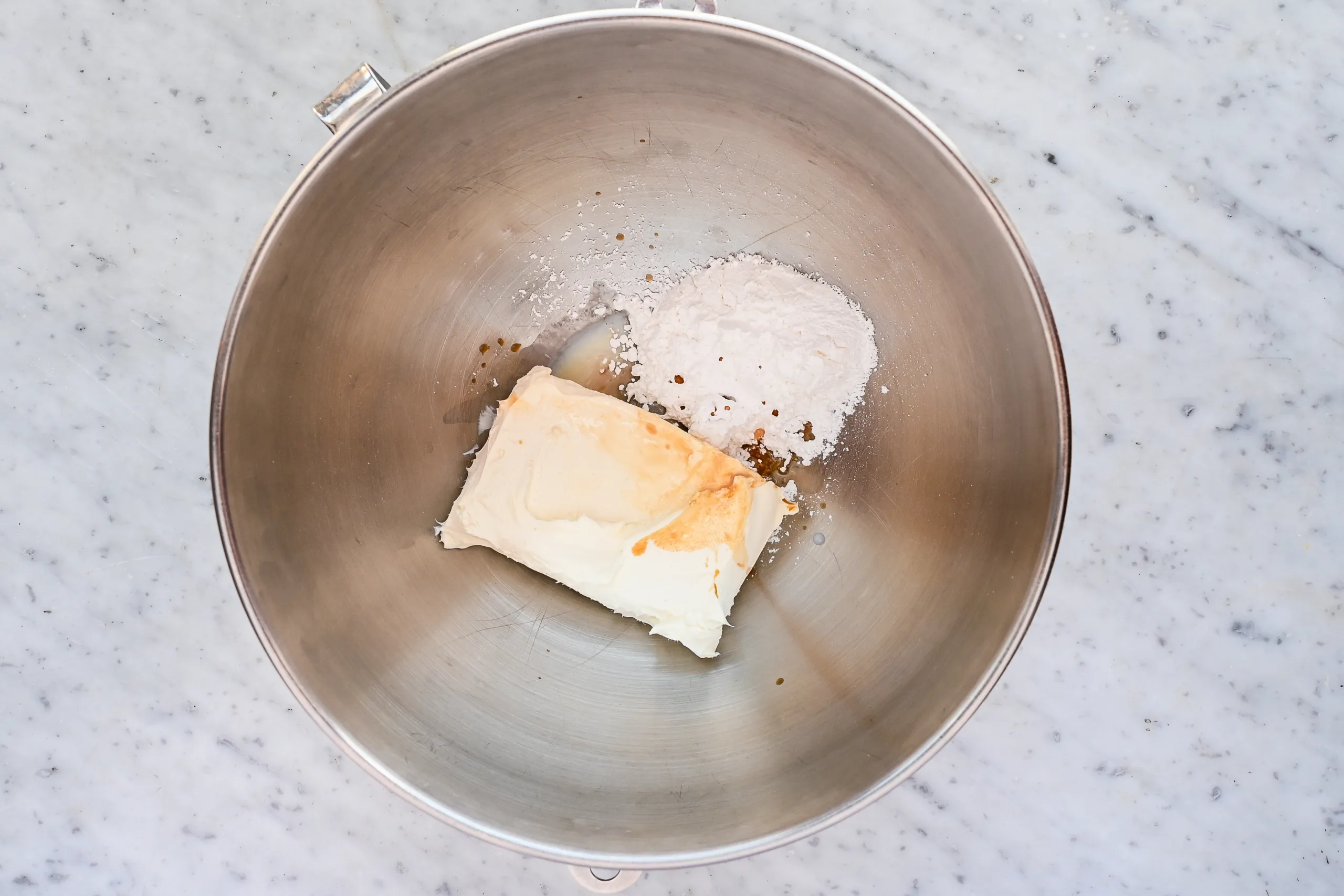 Cream cheese, powdered sugar, and vanilla extract in a mixing bowl for apple cream cheese Danish filling.