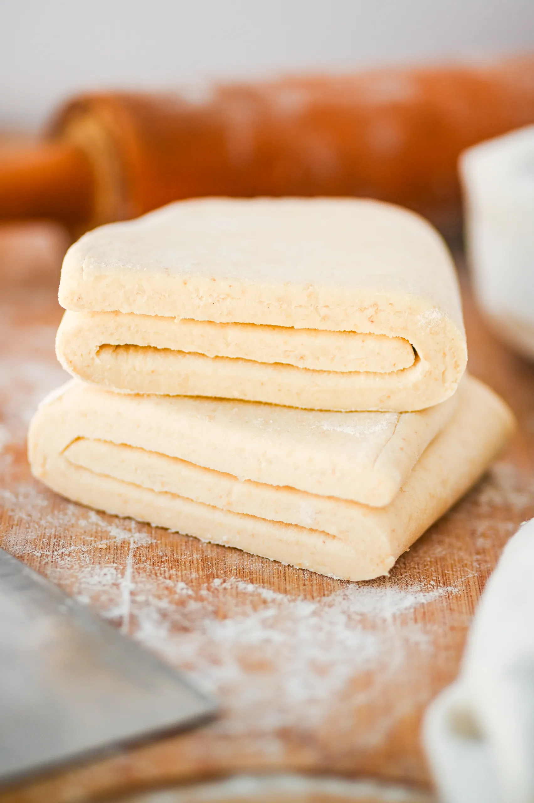 Sourdough puff pastry dough folded and resting on a floured surface ready for the next roll and fold.
