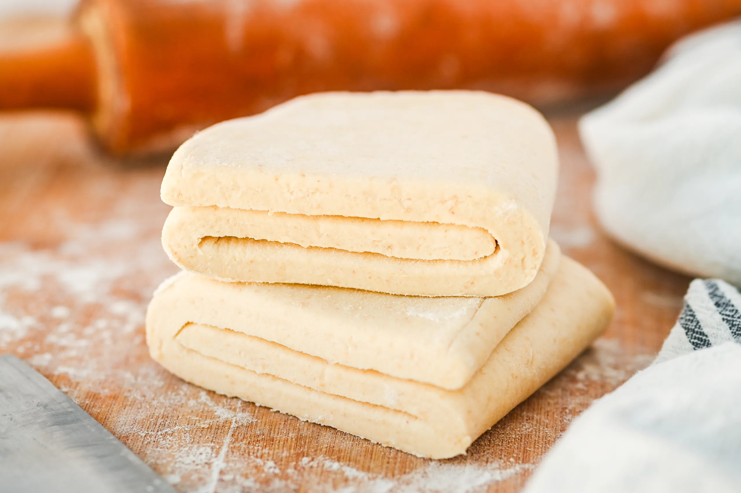 Close-up of laminated sourdough puff pastry dough after folding, showing layered structure before chilling.