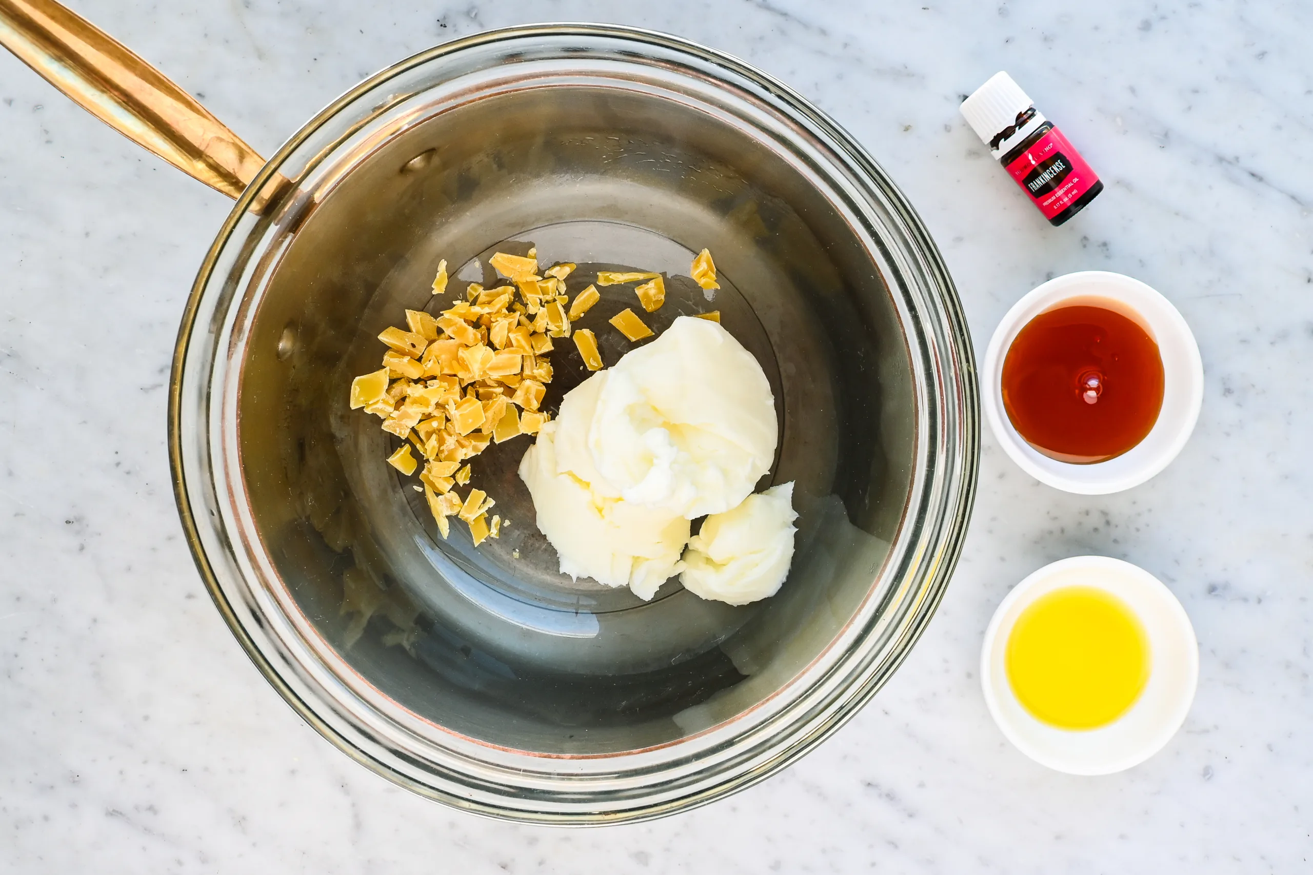 Beeswax and grass fed beef tallow melting together in a glass bowl as the base for homemade tallow and honey balm.