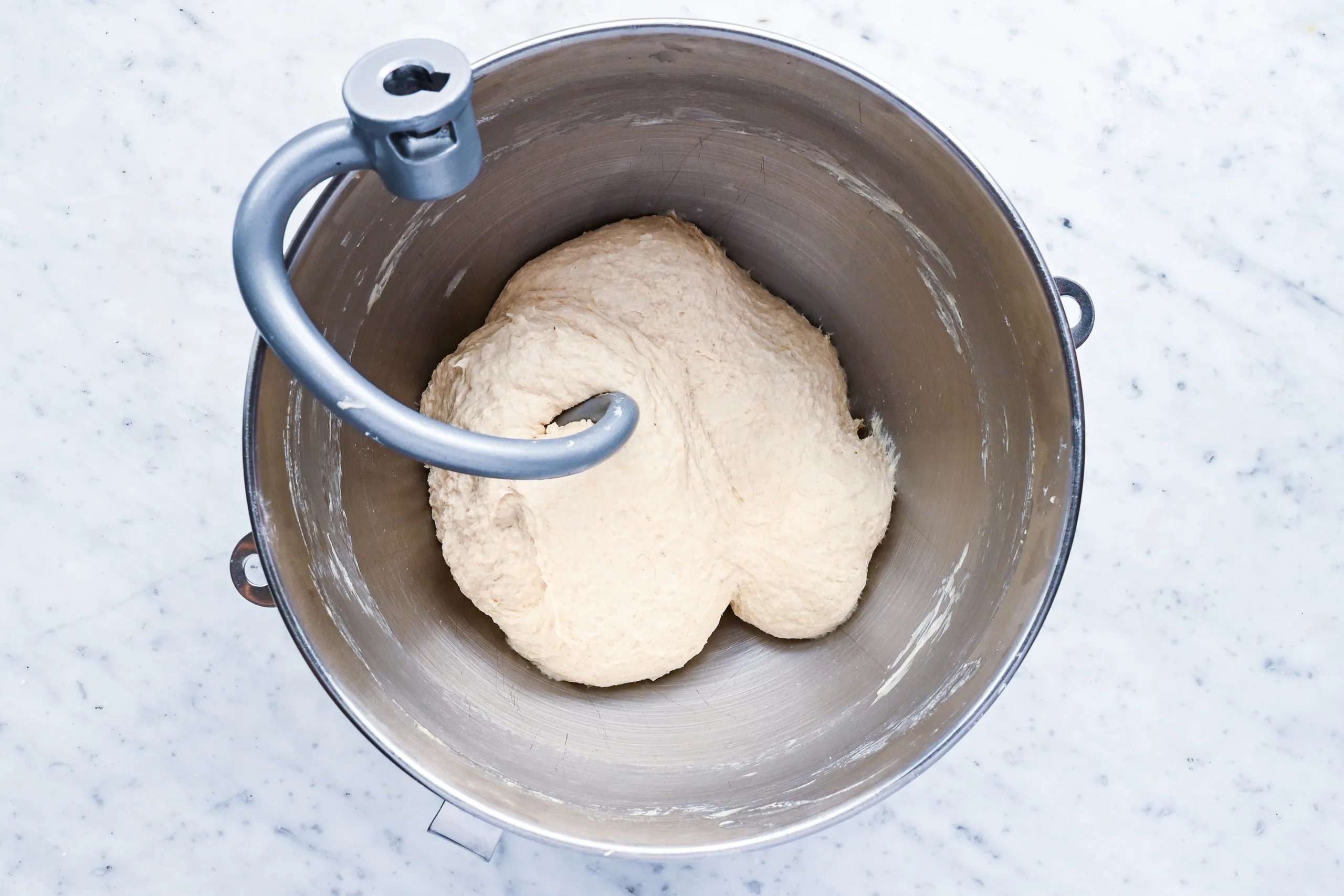 Sourdough discard sandwich bread dough kneading in a stand mixer with dough hook.