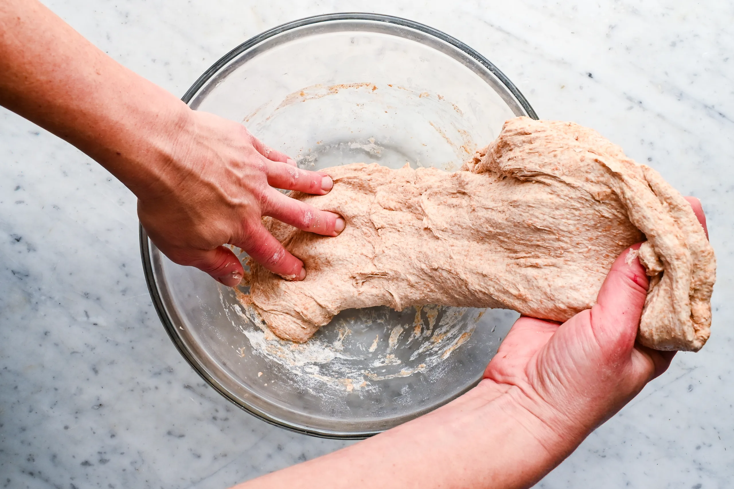Stretching fresh milled spelt sourdough dough by hand during mixing.