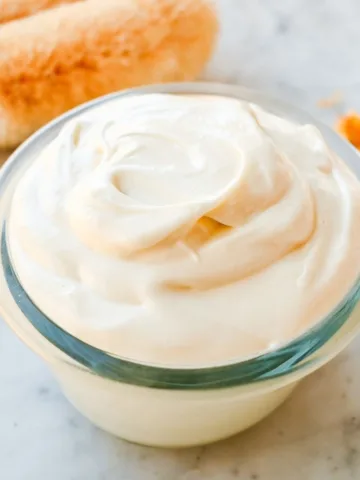 Homemade whipped tallow body butter with shea butter and cocoa butter in a small glass jar, whipped until light, smooth, and creamy.