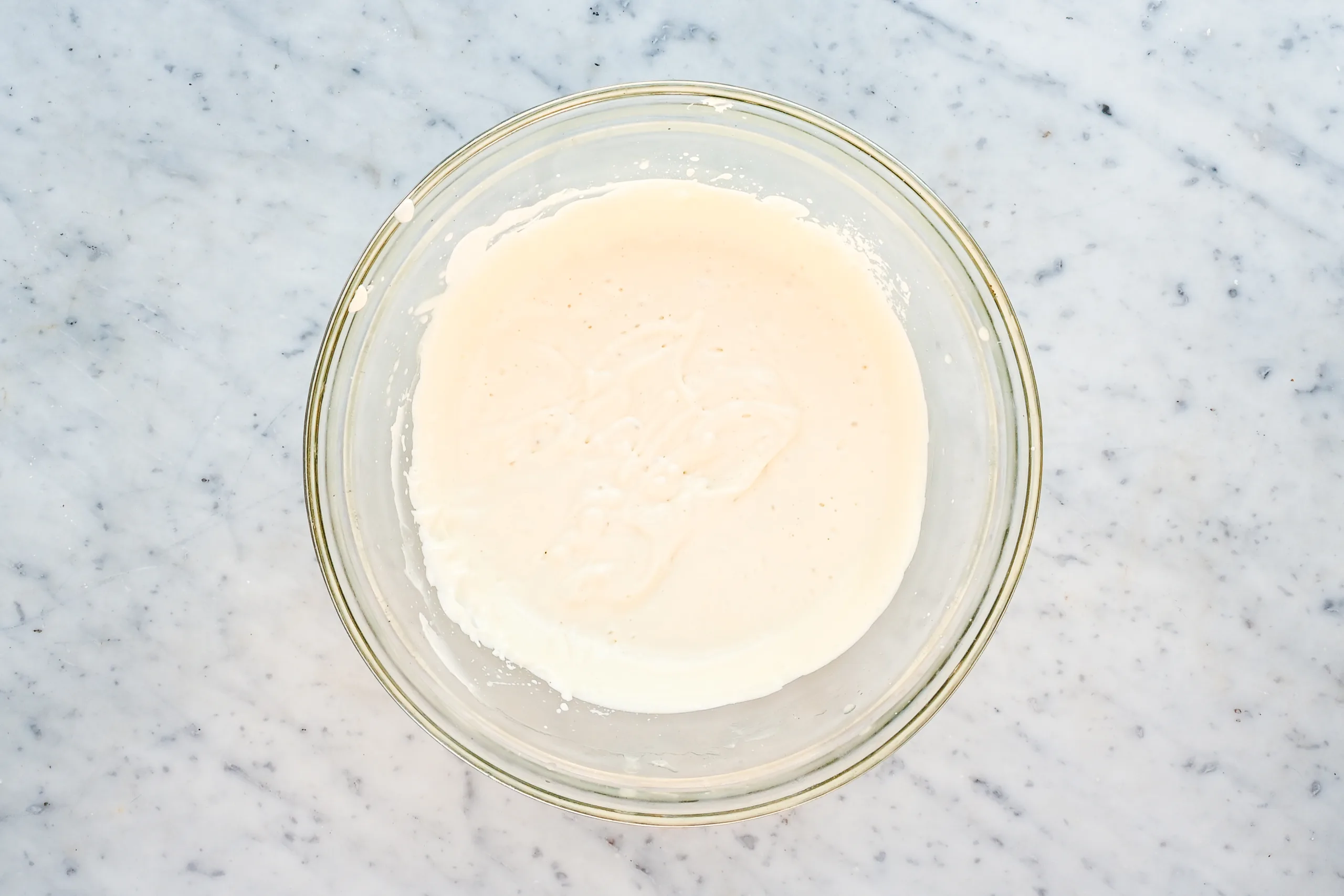 Whipped tallow body butter in a glass bowl with a light, fluffy texture after blending.