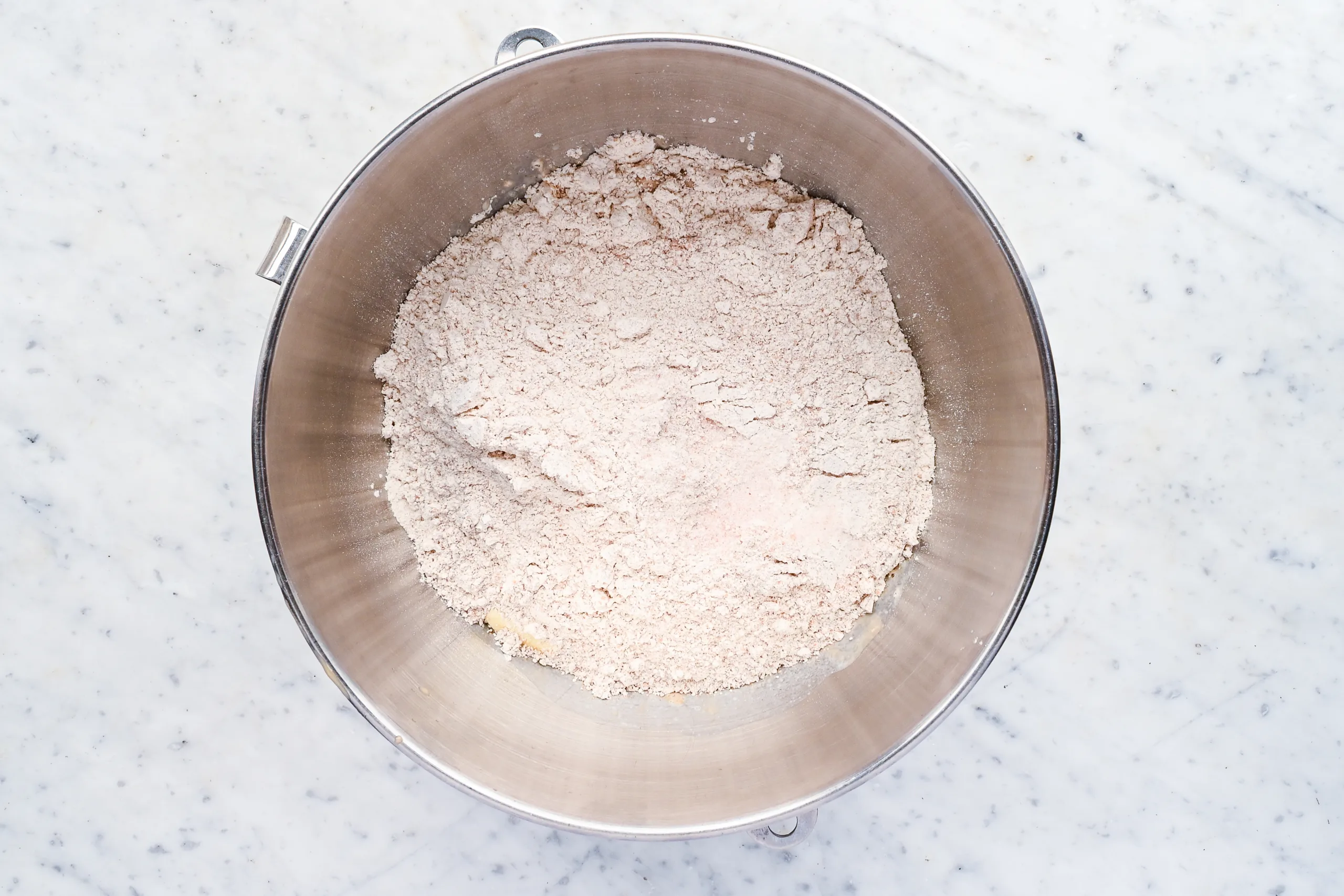 Fresh milled spelt flour added to the stand mixer bowl for whole grain spelt bread dough.