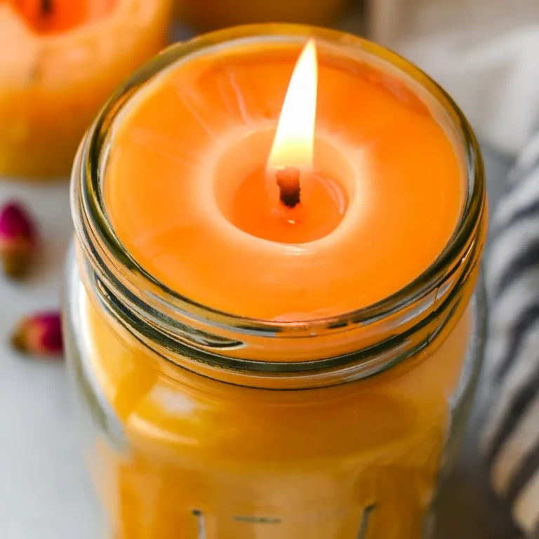Close-up of a lit beeswax candle in a mason jar with a smooth melt pool around the wick