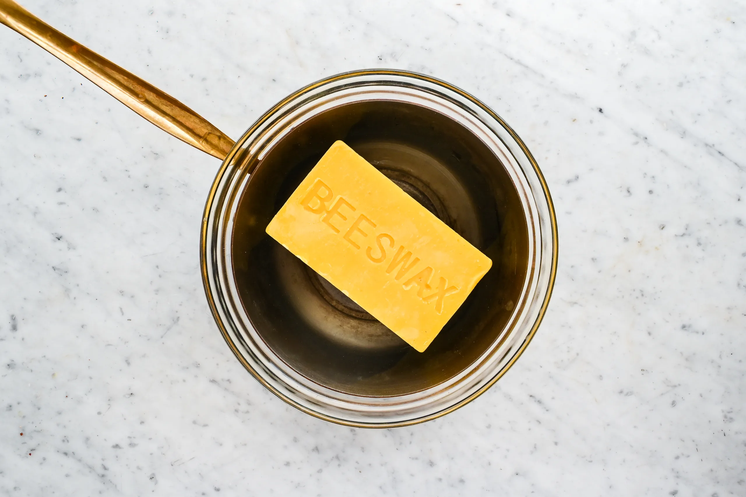 Block of beeswax in a double boiler before melting for a mason jar candle