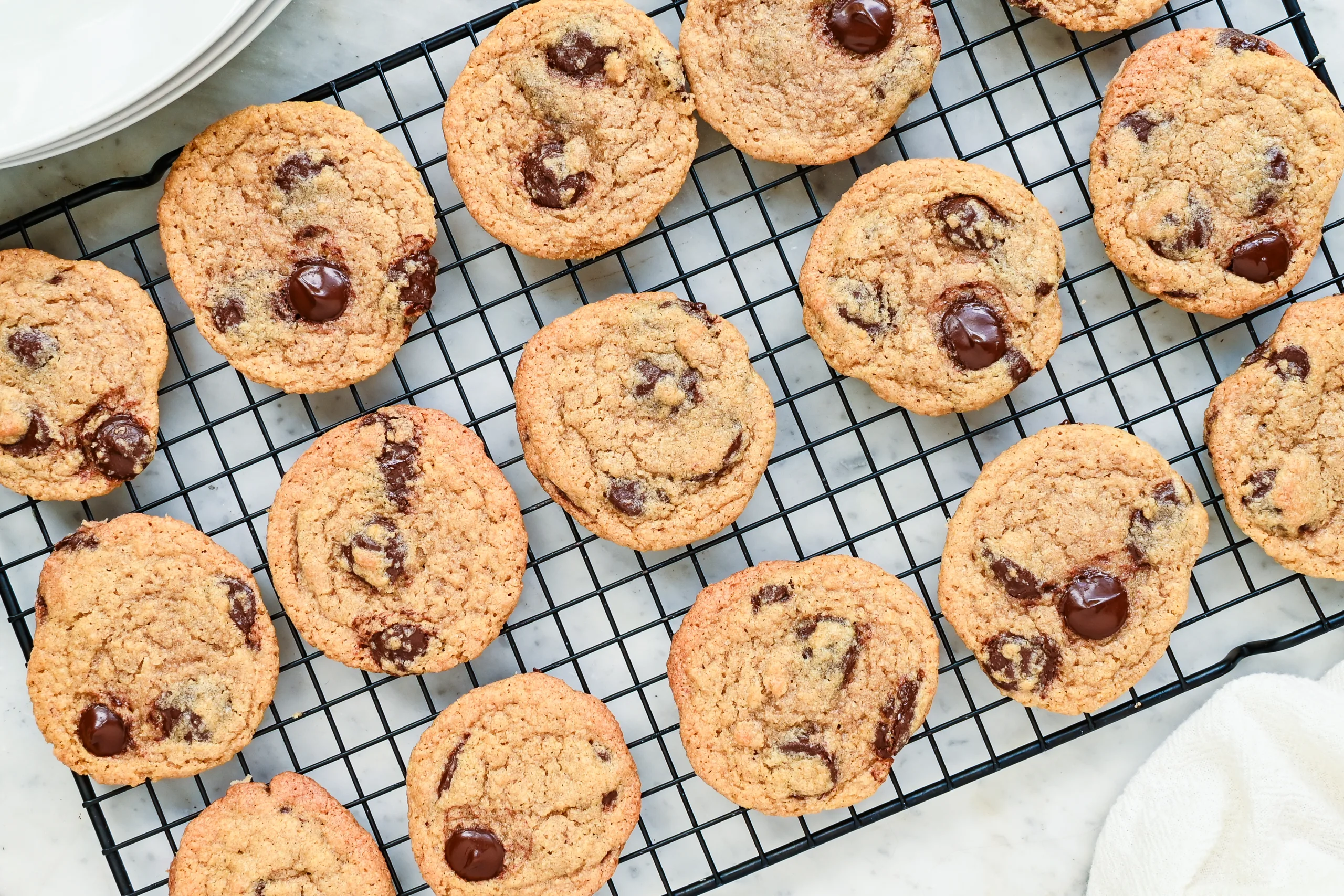 Whole wheat chocolate chip cookies cooling on a wire rack.