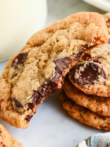 Broken whole wheat chocolate chip cookie showing melted chocolate chips and a soft center.
