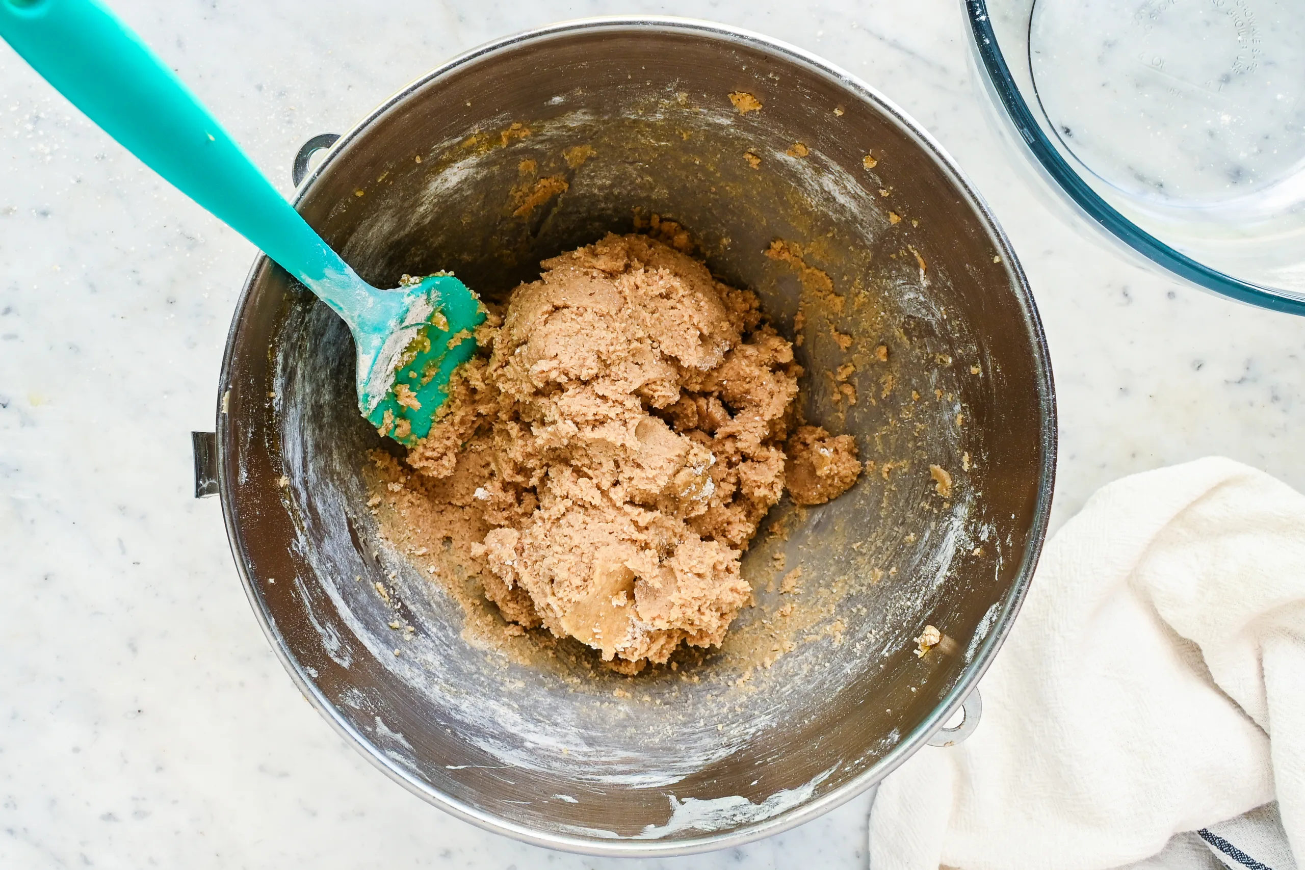 Mixed whole wheat chocolate chip cookie dough in a stand mixer bowl.