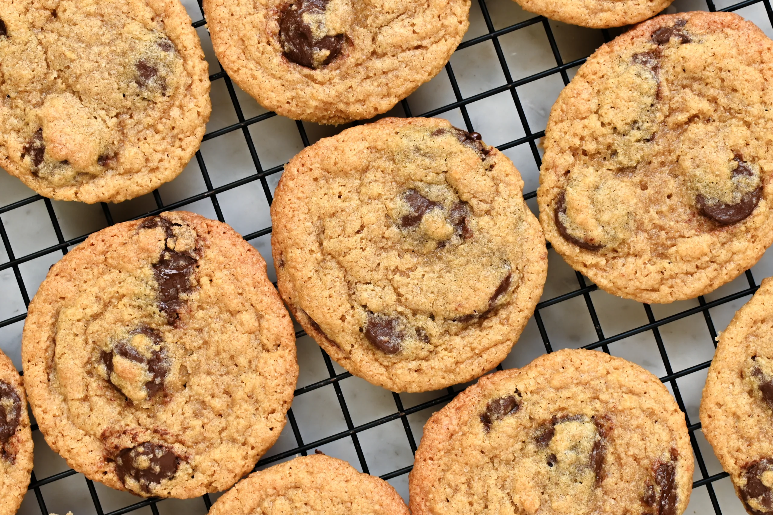 Close-up of whole wheat chocolate chip cookies cooling on a wire rack.