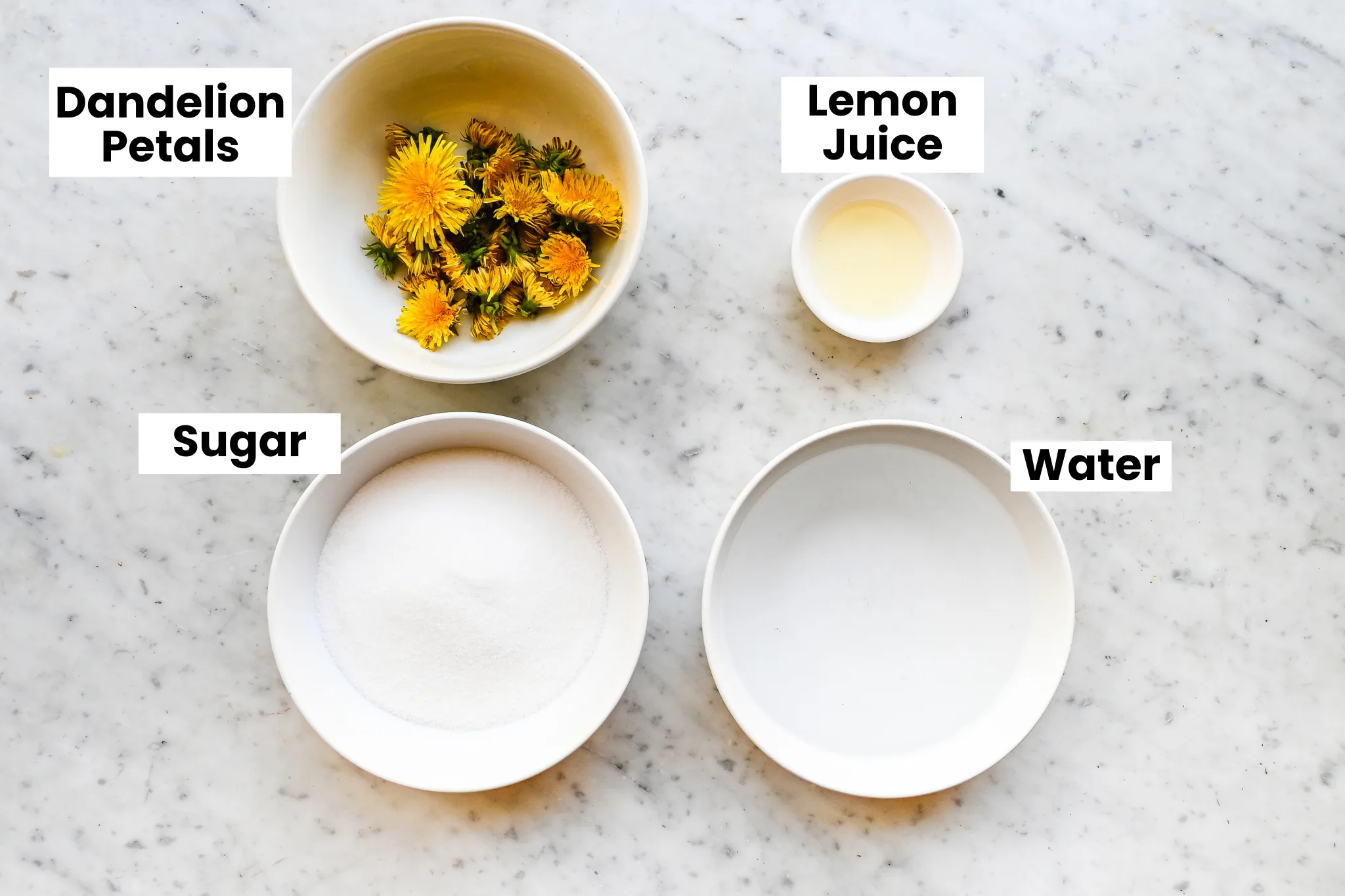 Ingredients for dandelion honey including dandelion flowers, sugar, lemon juice, and water.