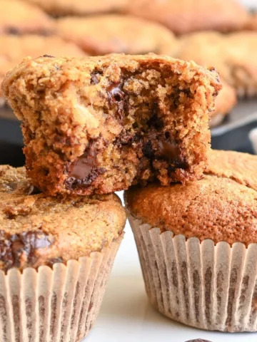 Whole wheat banana chocolate chip muffin broken open to show melted chocolate and a soft, moist center.