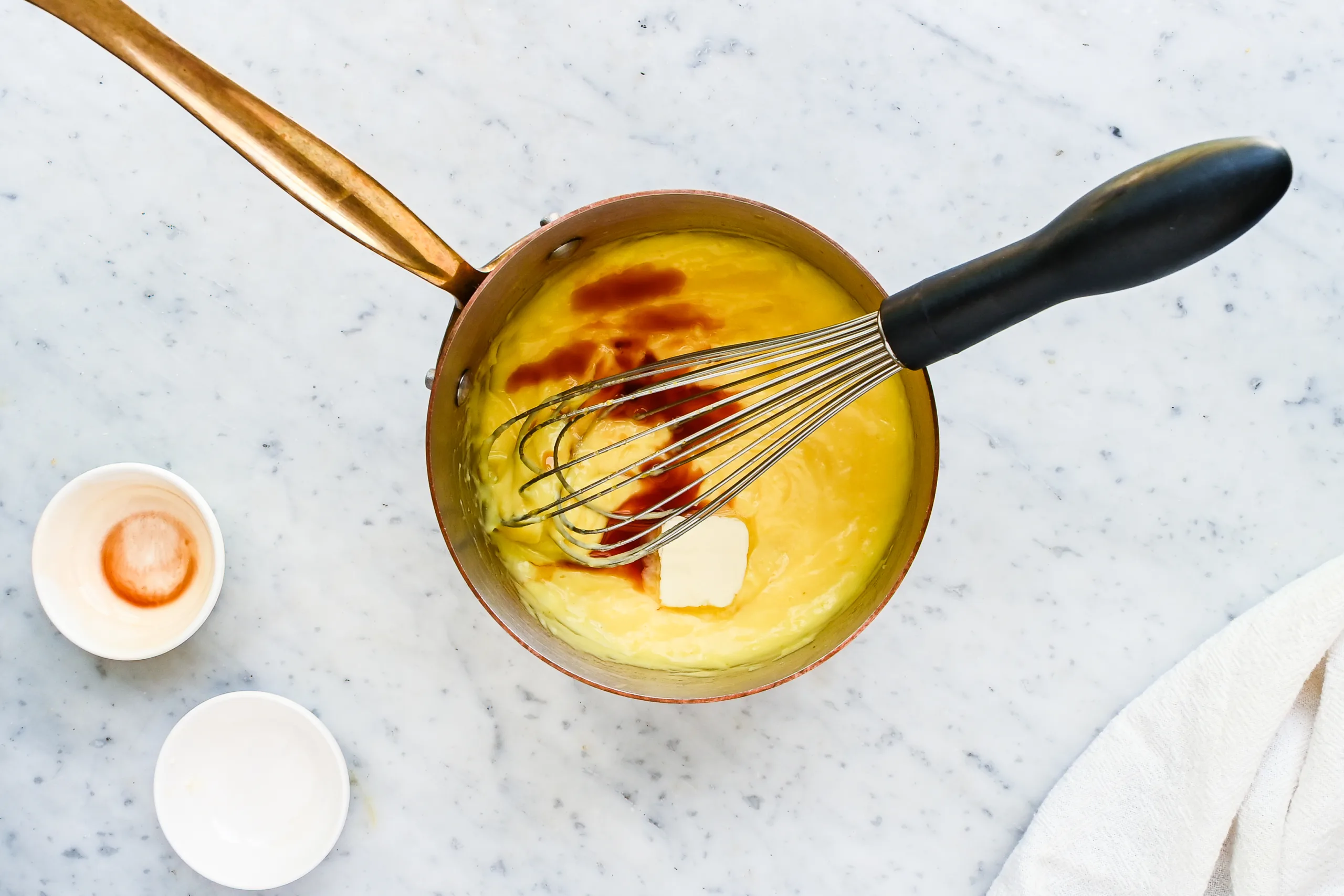 Thick vanilla cream filling with butter and vanilla in a saucepan for a fresh berry cream tart.