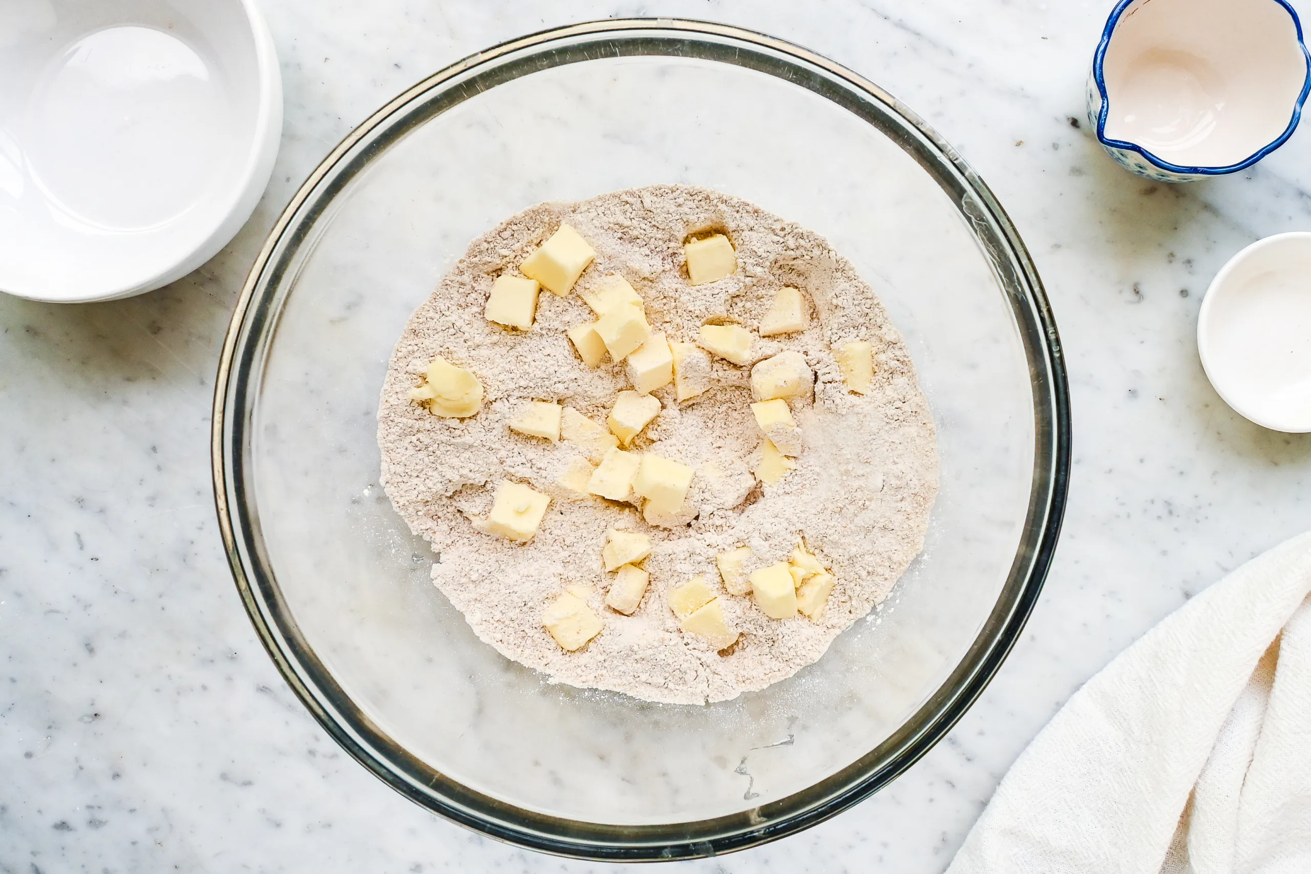 Cold cubed butter added to flour mixture for a fresh milled wheat tart crust.