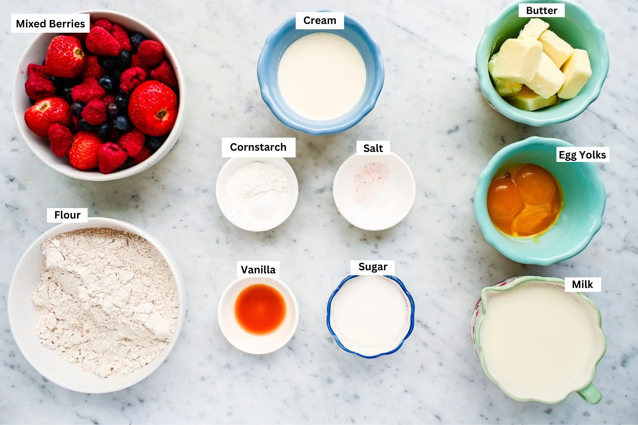 Ingredients for an easy cream tart recipe with fresh berries, flour, milk, egg yolks, butter, sugar, cornstarch, vanilla, and cream.